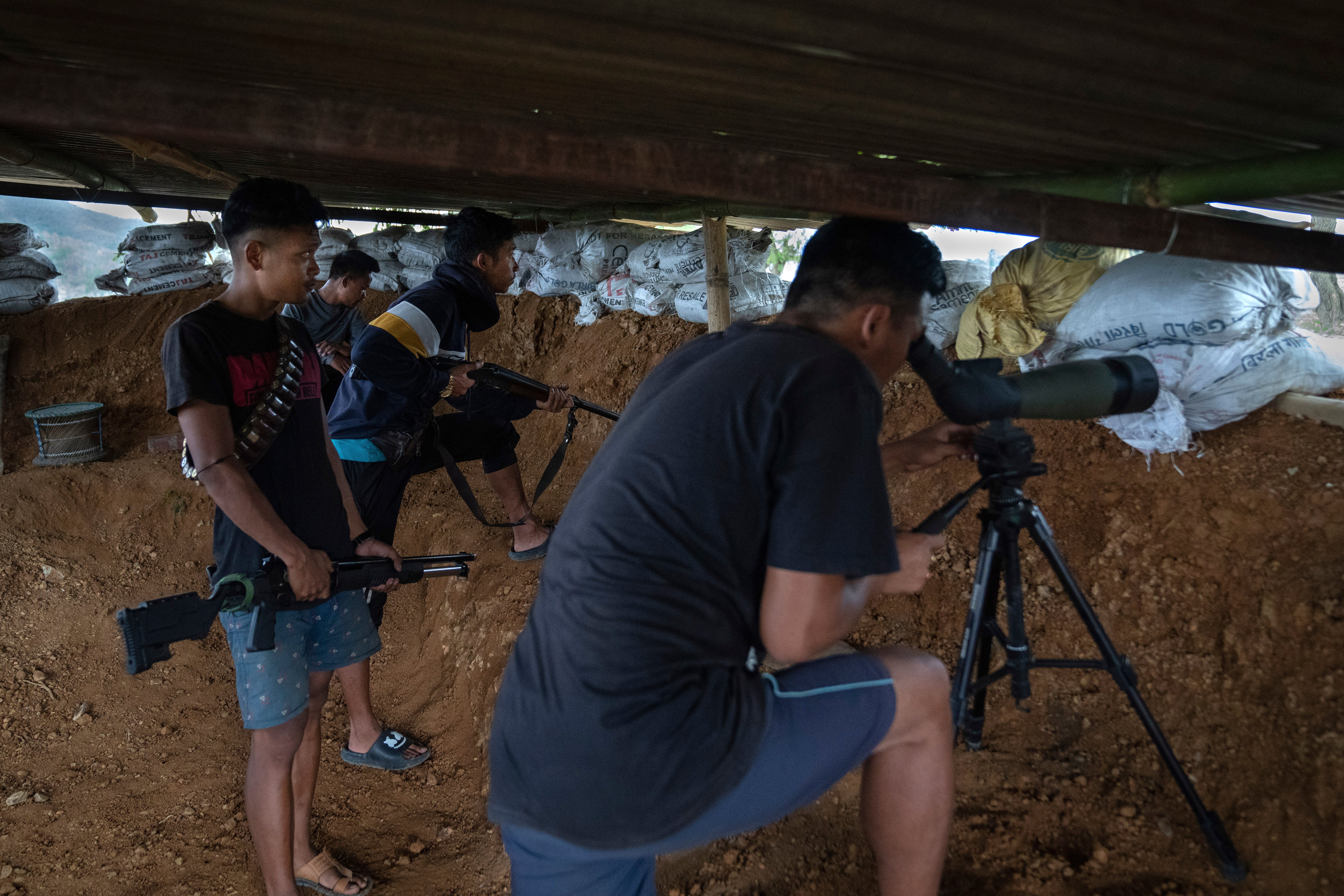 Armed Meitei community members keep a watch from a bunker on rival tribal Kuki community bunkers