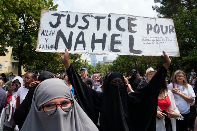 <p>A woman shows a poster ‘Justice for Nahel’ during a march for 17-year-old Nahel</p>
