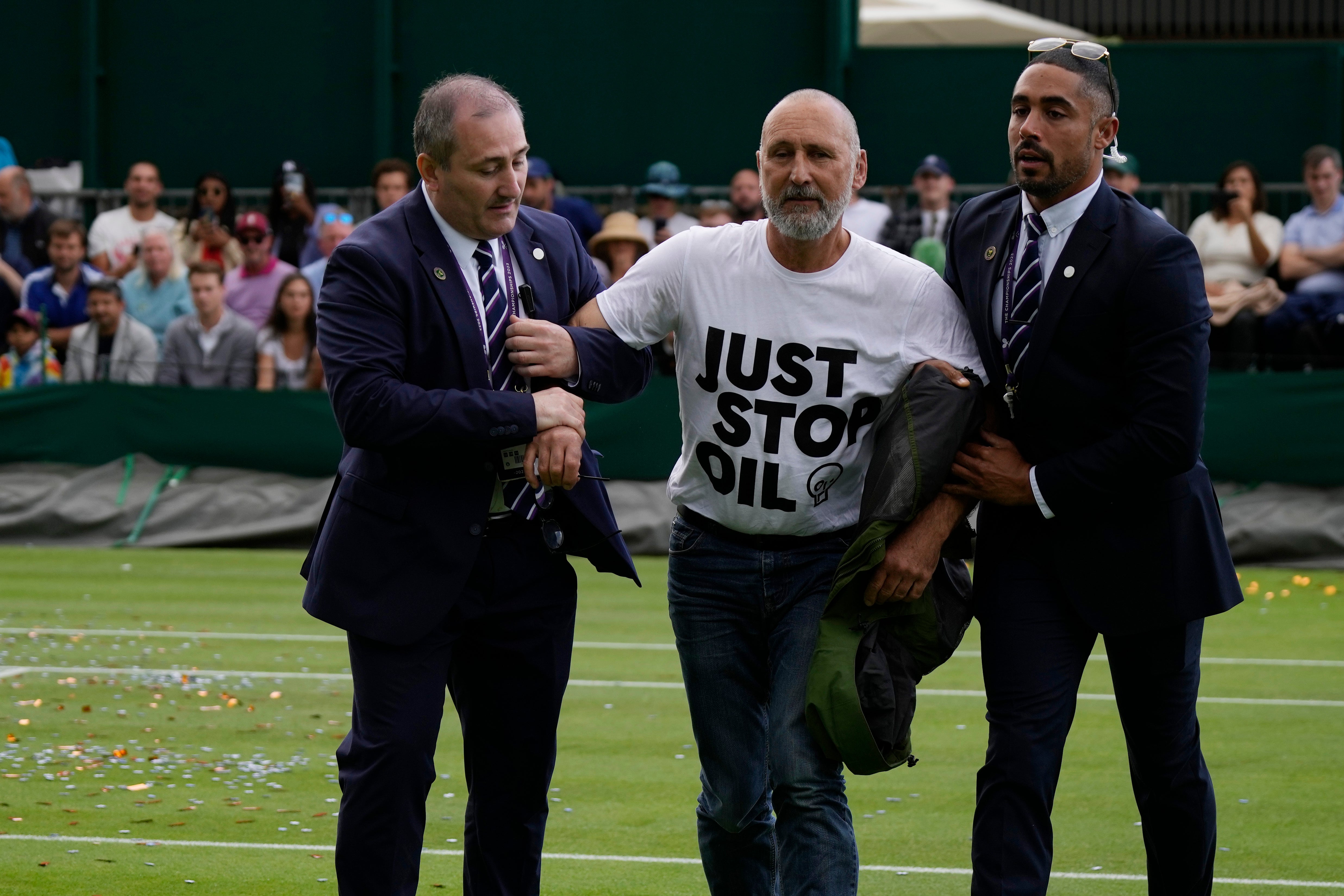 A Just Stop Oil protester is removed from Court 18 on day three of the Wimbledon tennis championships