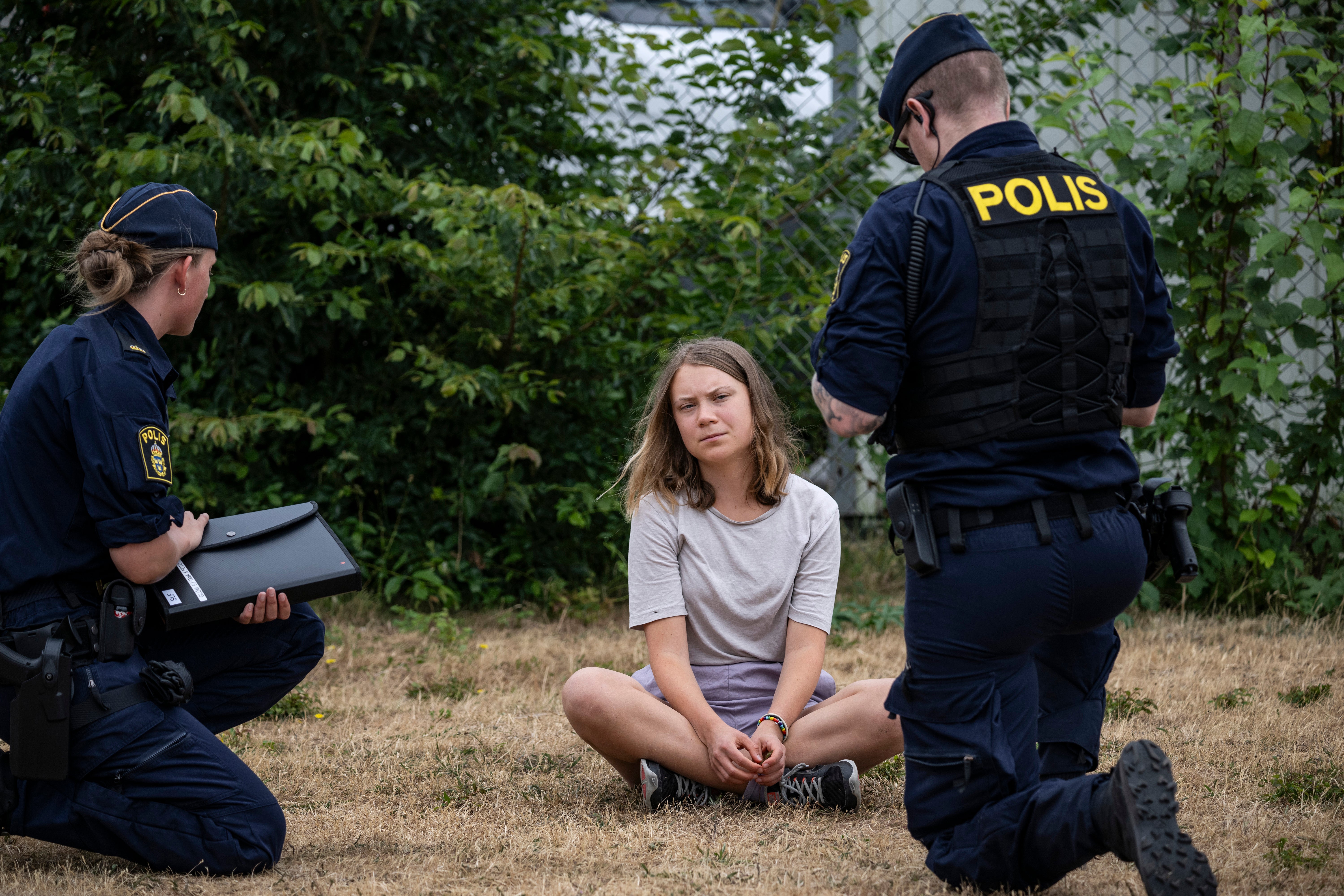 Police officers talk to the Swedish climate activist Greta Thunberg at the protest in June