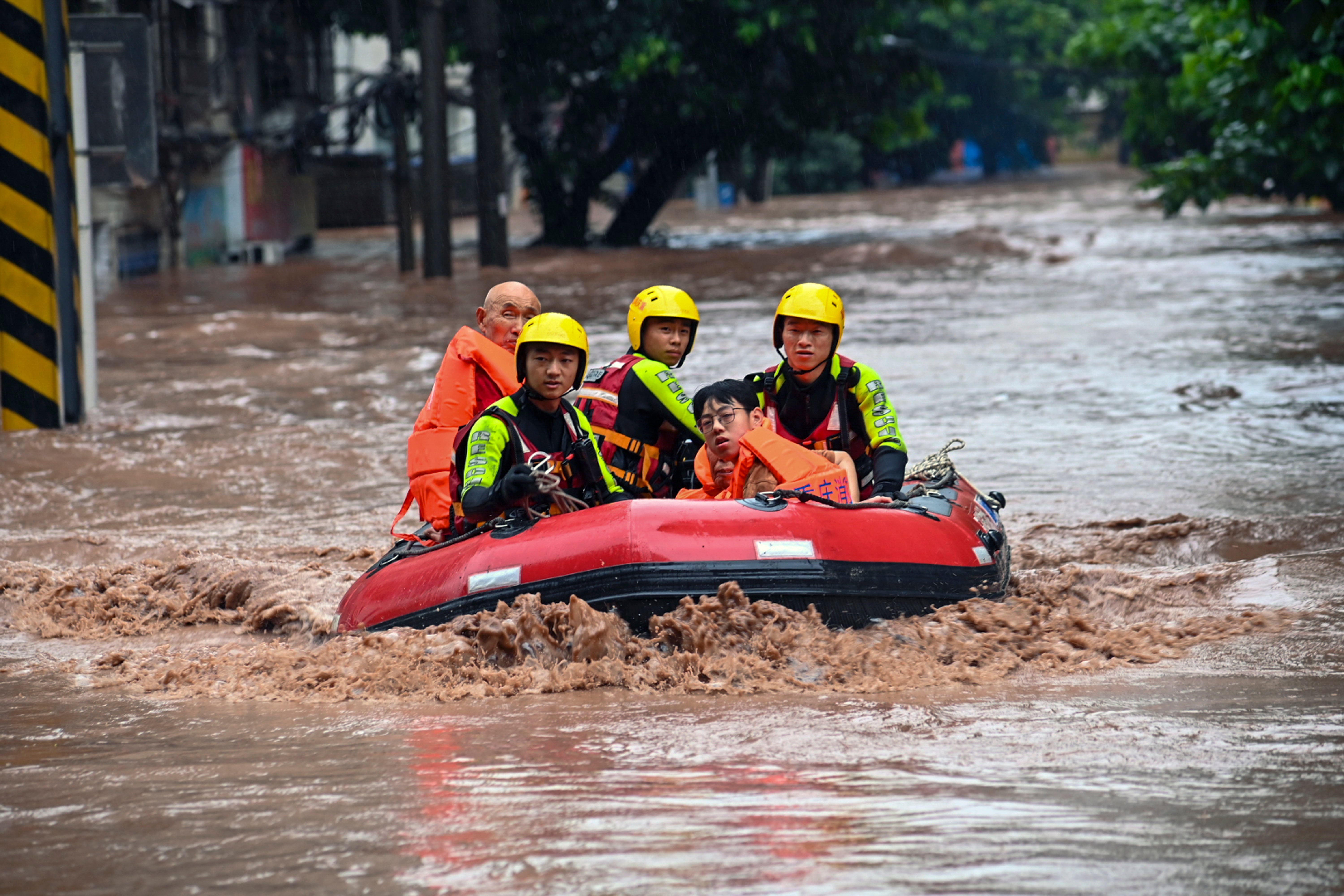 Rescuers evacuate flood trapped residents following a flood in Wanzhou District, in southwest China