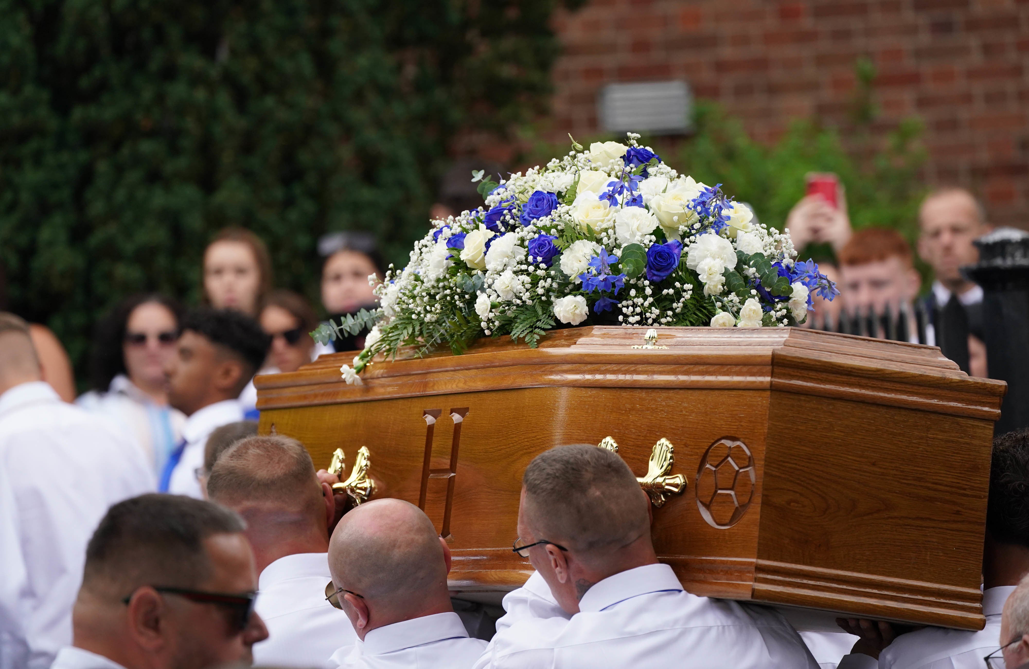 The coffin of Harvey is carried into the Church of the Resurrection in Ely, Cardiff