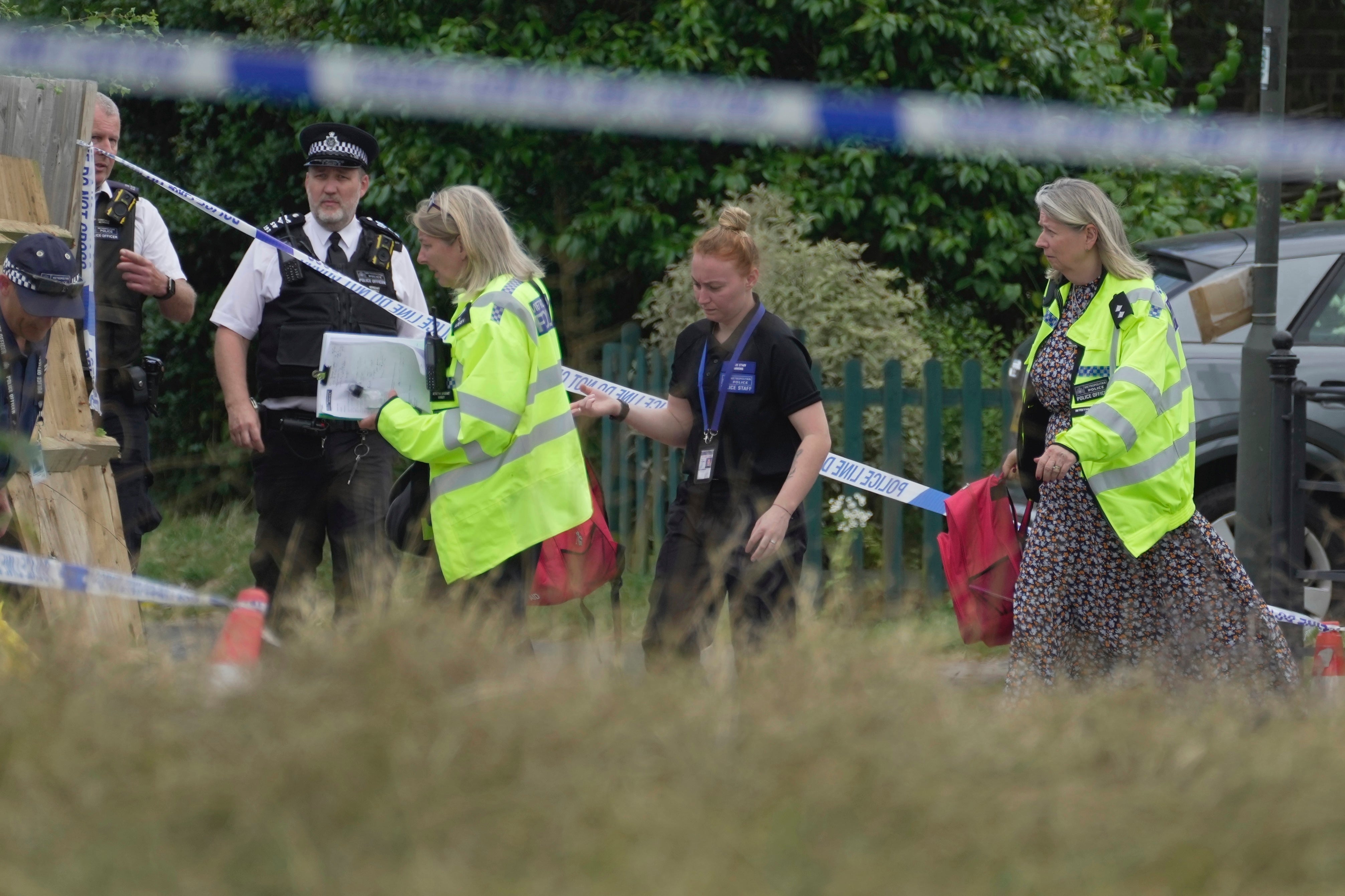 Police officers investigate the scene of the crash on the edge of Wimbledon Common