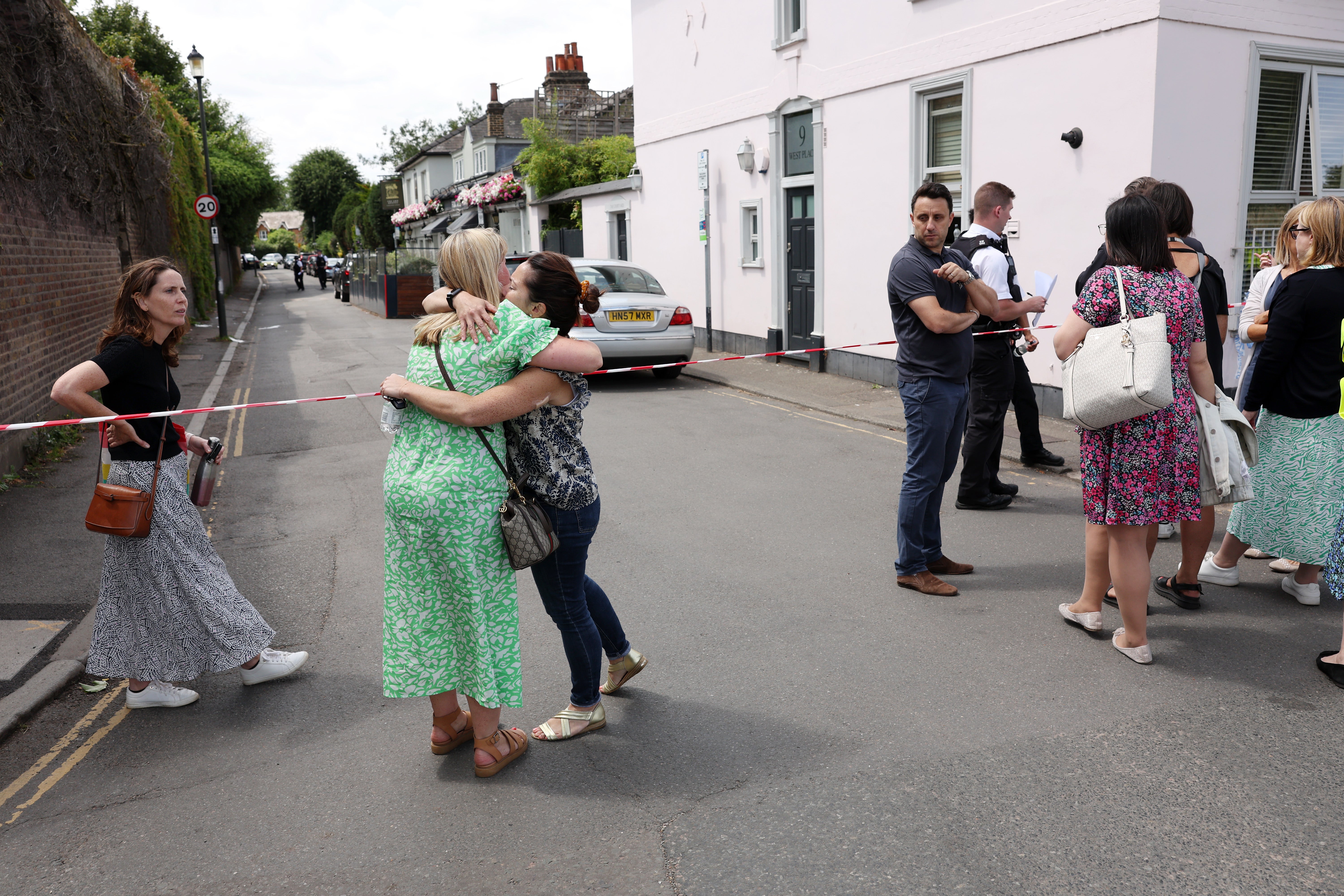 People gather outside a cordon at the scene of the car crash