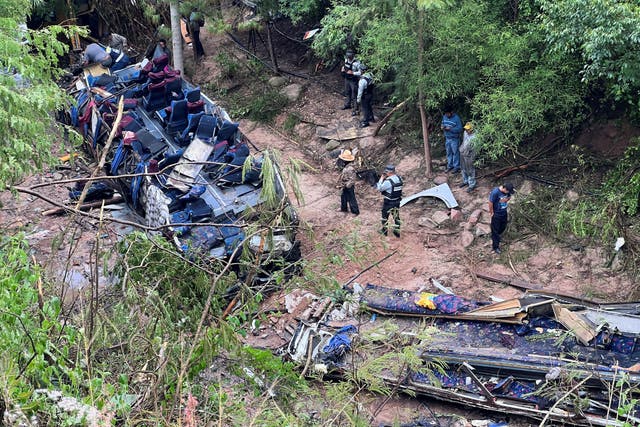 <p>Authorities and volunteers work at the site of the bus crash</p>