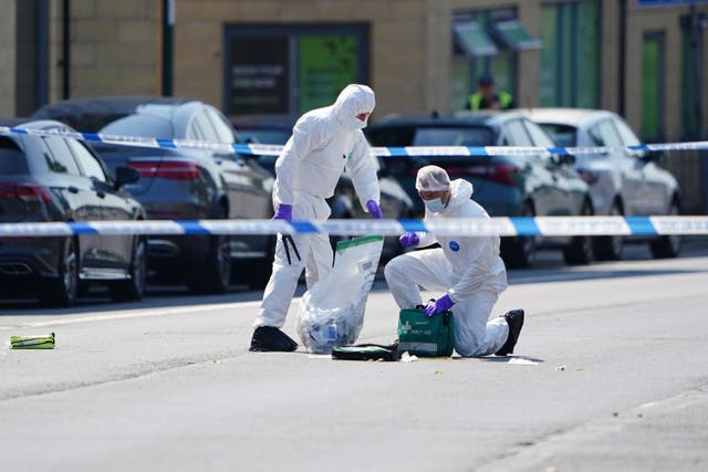 Police forensics officers pictured on Ilkeston Road after three people were killed in Nottingham city centre (PA)