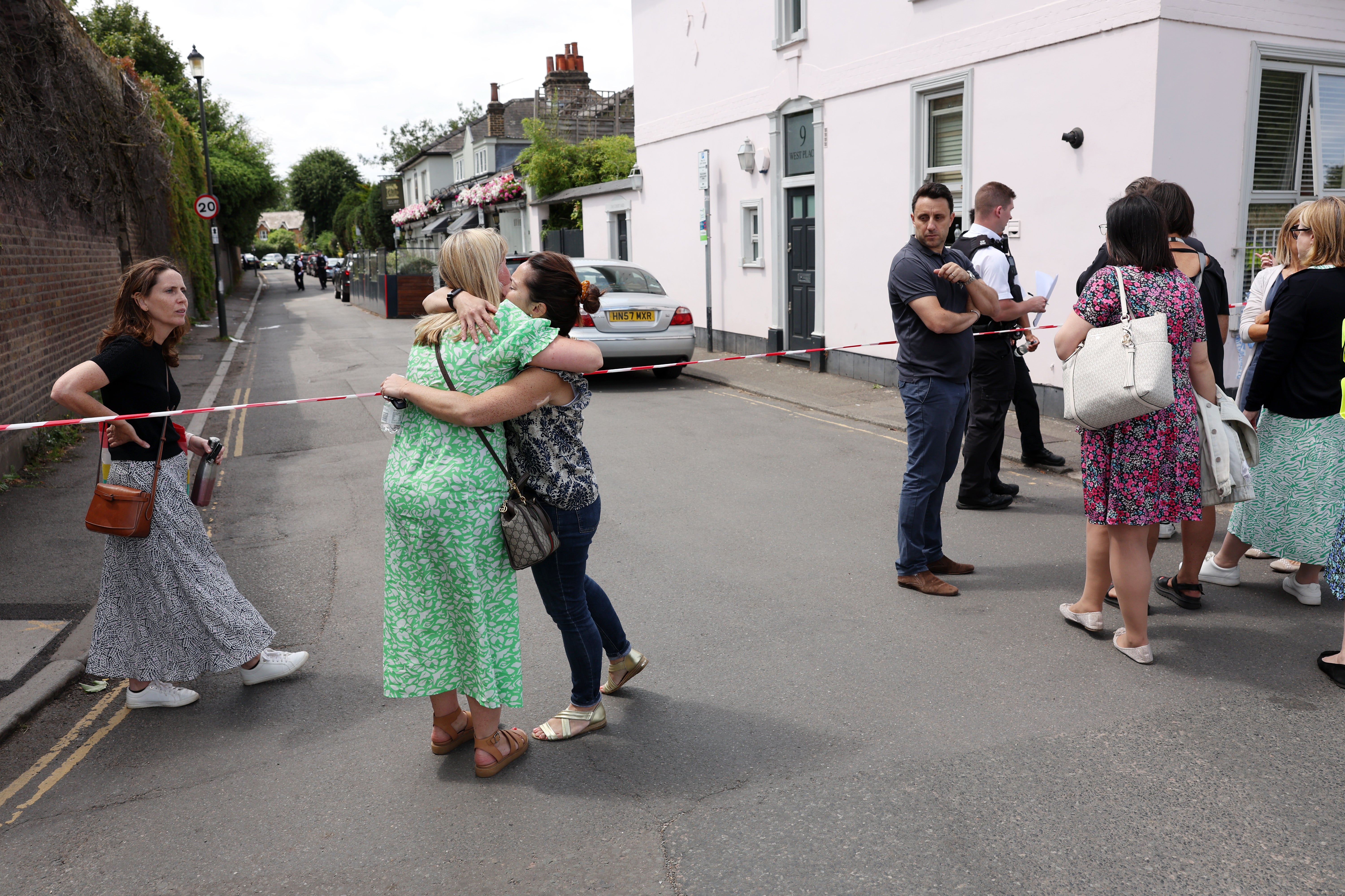 pPeople gather outside a cordon at the scene of a car crash at a school on 6 July 2023 in Wimbledon, England/p