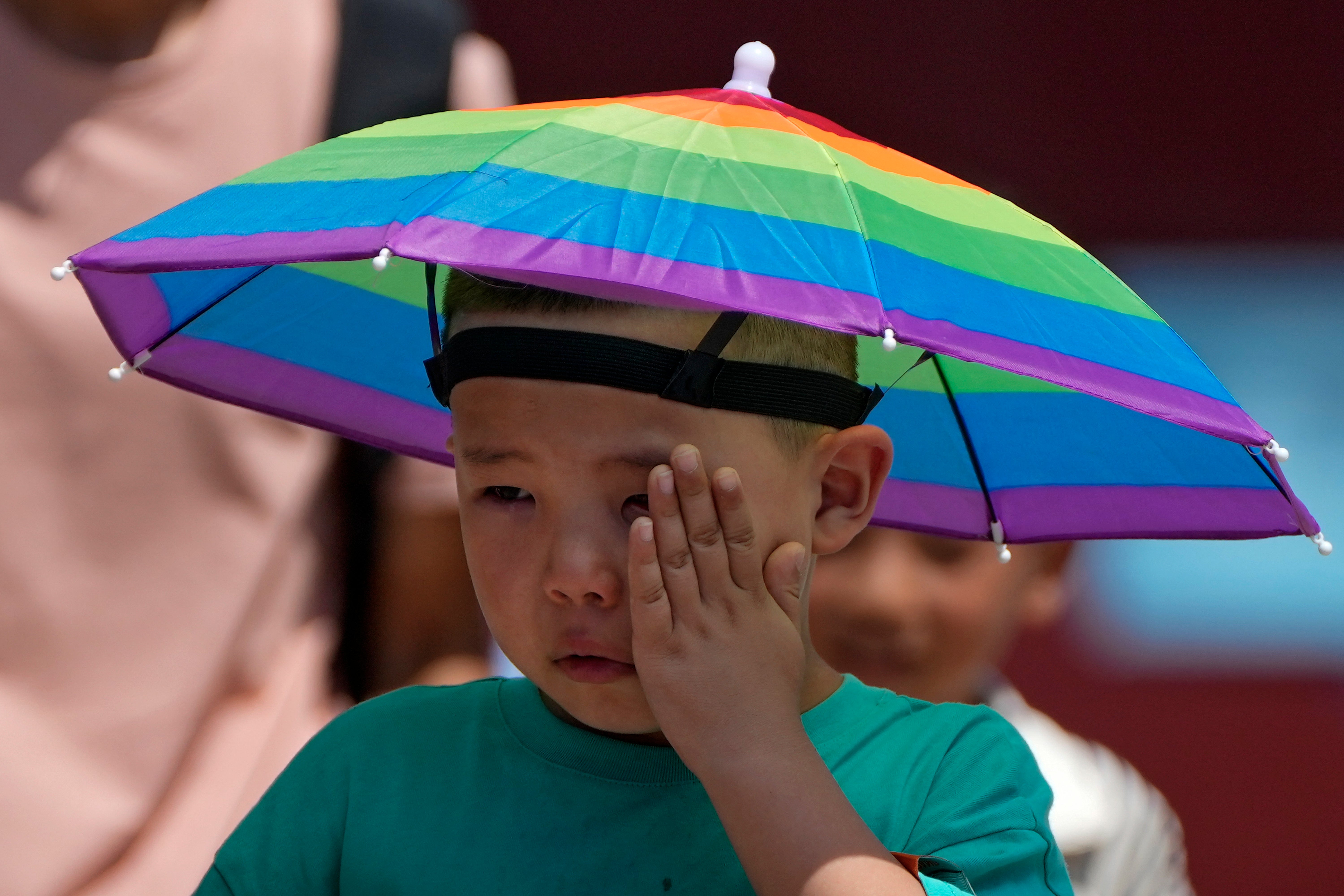 A boy wipes his sweat as he visits the Forbidden City on a sweltering day in Beijing on Friday