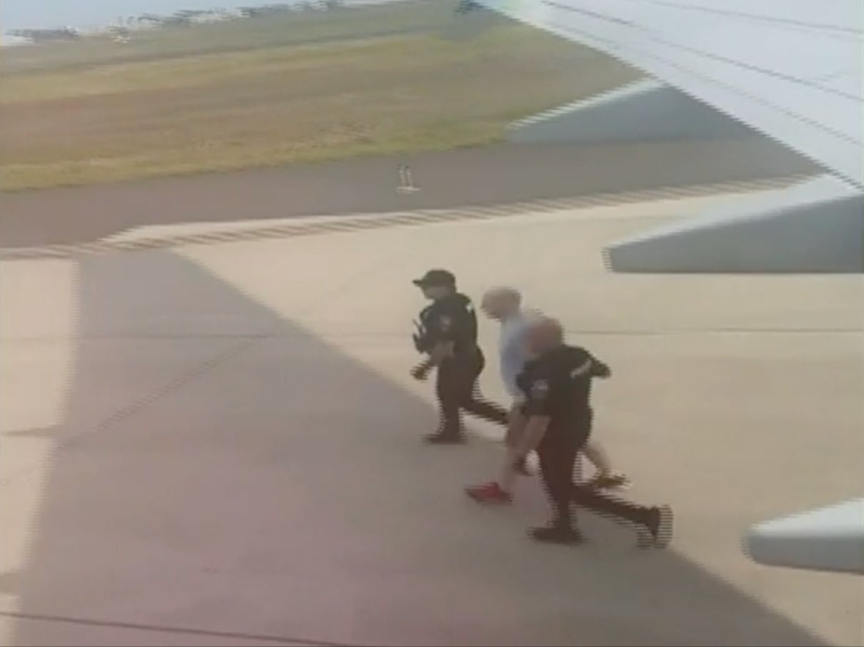 A man is lead away in handcuffs on 5 July, 2023, at the Spokane, Washington, airport after allegedly making a bomb threat