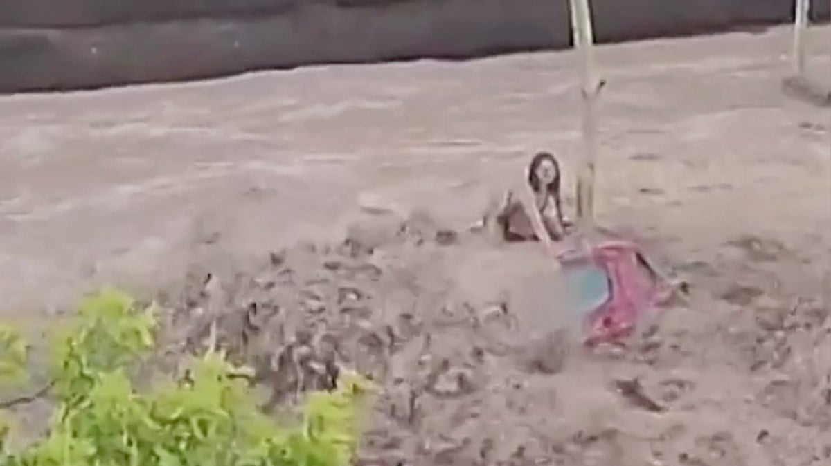 Woman clings to roof of car as flash floods wash vehicles away in Spain