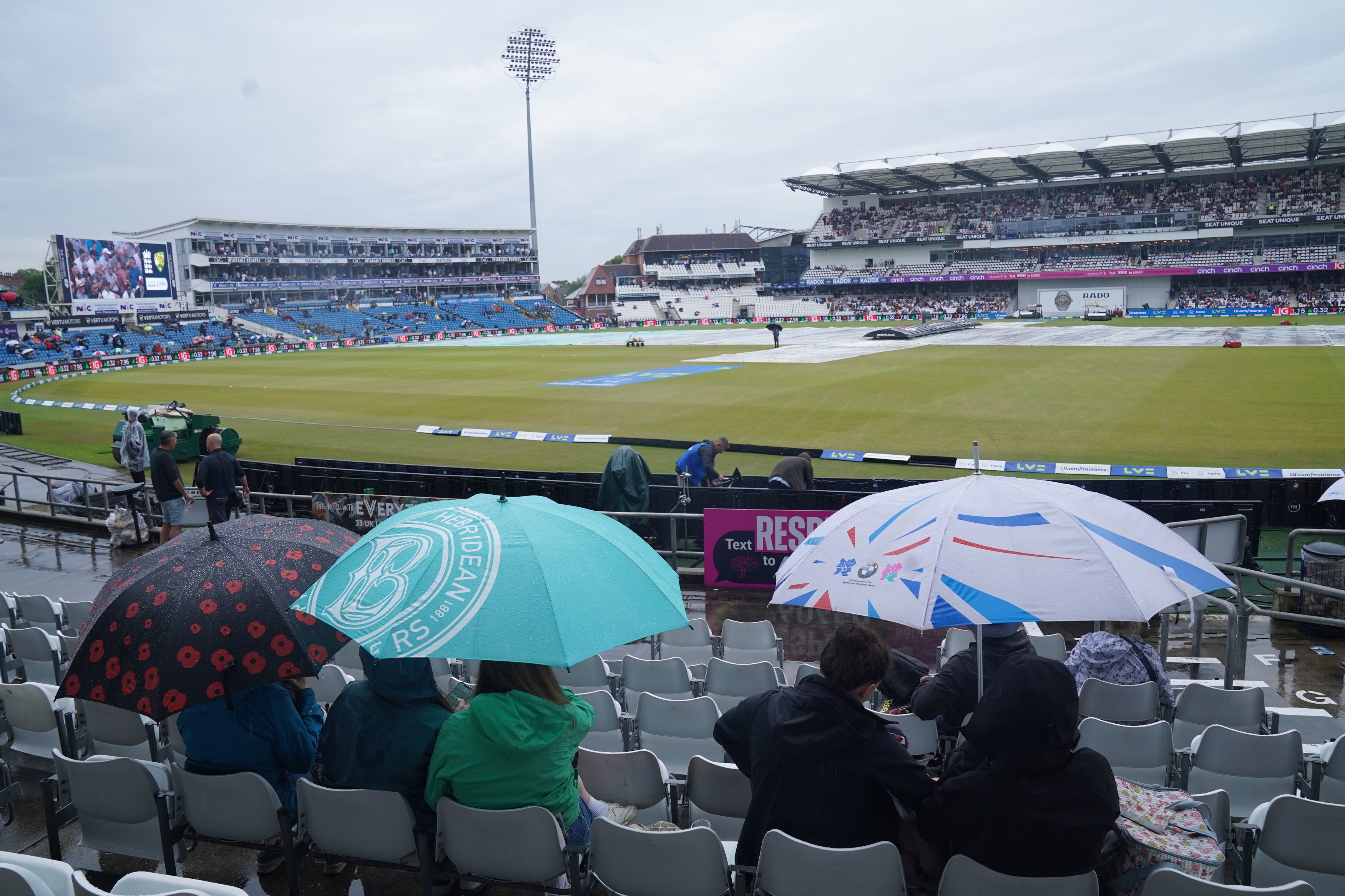 Spectators shelter under umbrellas during day three of the Ashes Series test match at Headingley