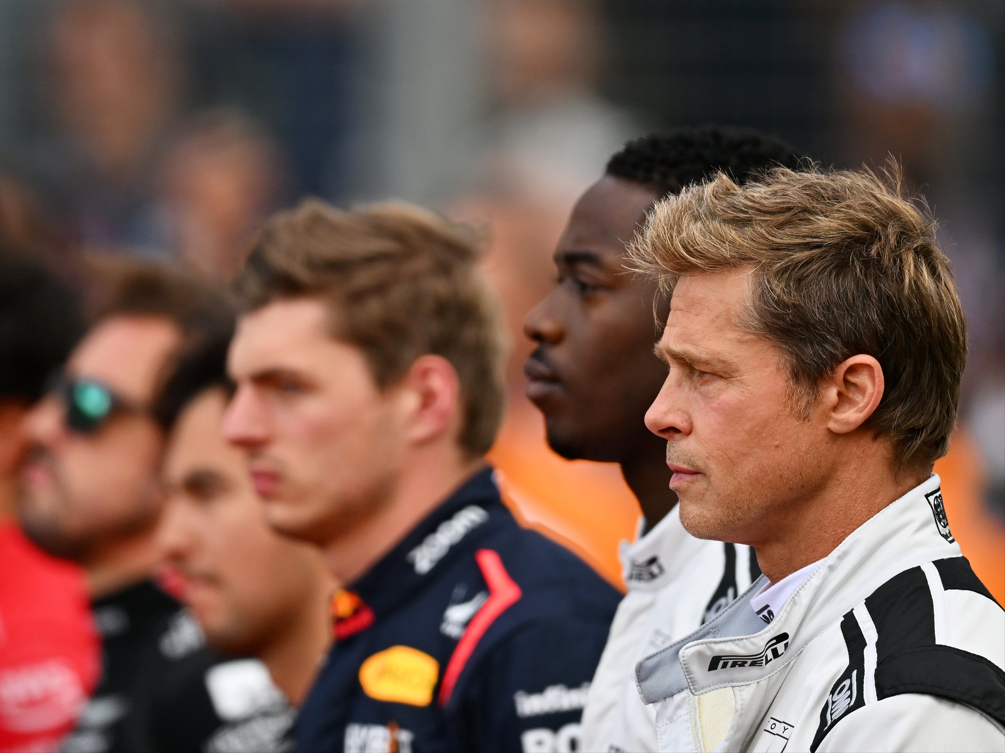 Brad Pitt and co-star Damson Idris stand for the national anthem on the grid during the F1 Grand Prix of Great Britain at Silverstone Circuit