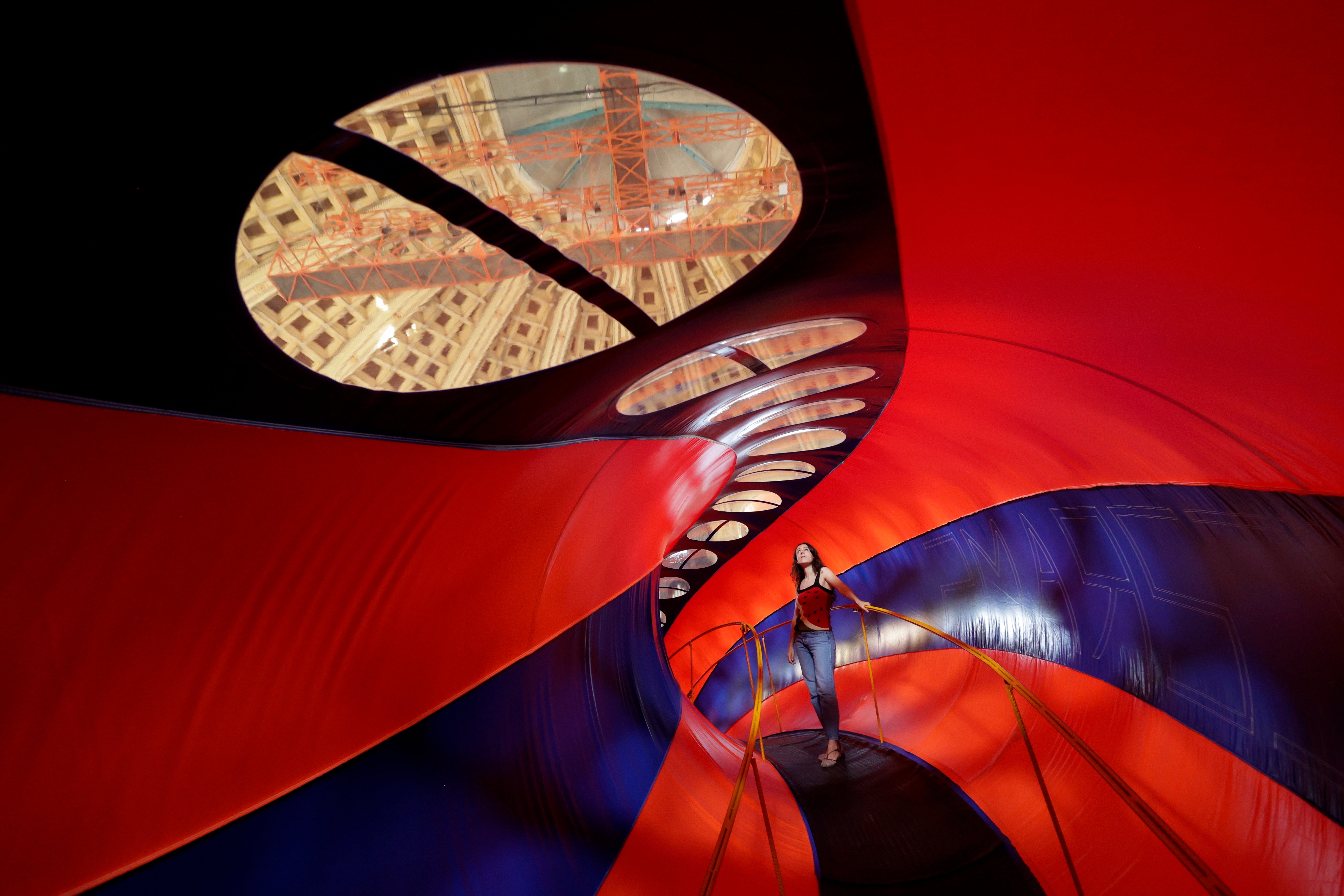 Artist Laia Estruch poses in her giant sound sculpture in the shape of a braid, entitled 'Trena', on display in the Oval Room of the MNAC Museum in Barcelona, Spain, 10 July 2023. The artwork is made up of three braided inflatable tubes 2.2 meters in diameter by 35 meters long and that is performative since it is activated every hour on the hour with a piece of music lasting one minute and 48 seconds, produced with the collaboration of Xavi Lloses.