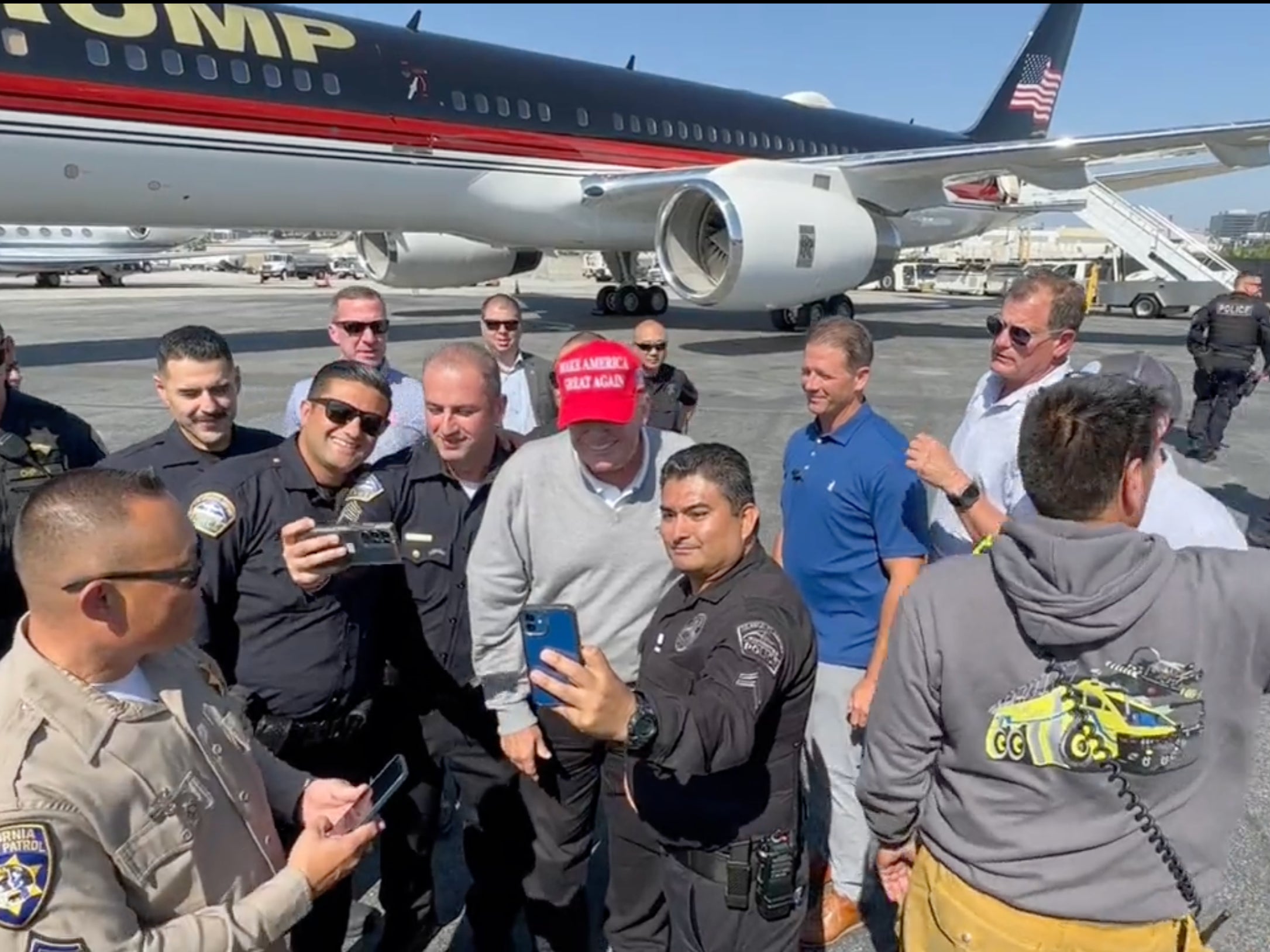 Mr Trump poses for photos with law enforcement officers in Los Angeles