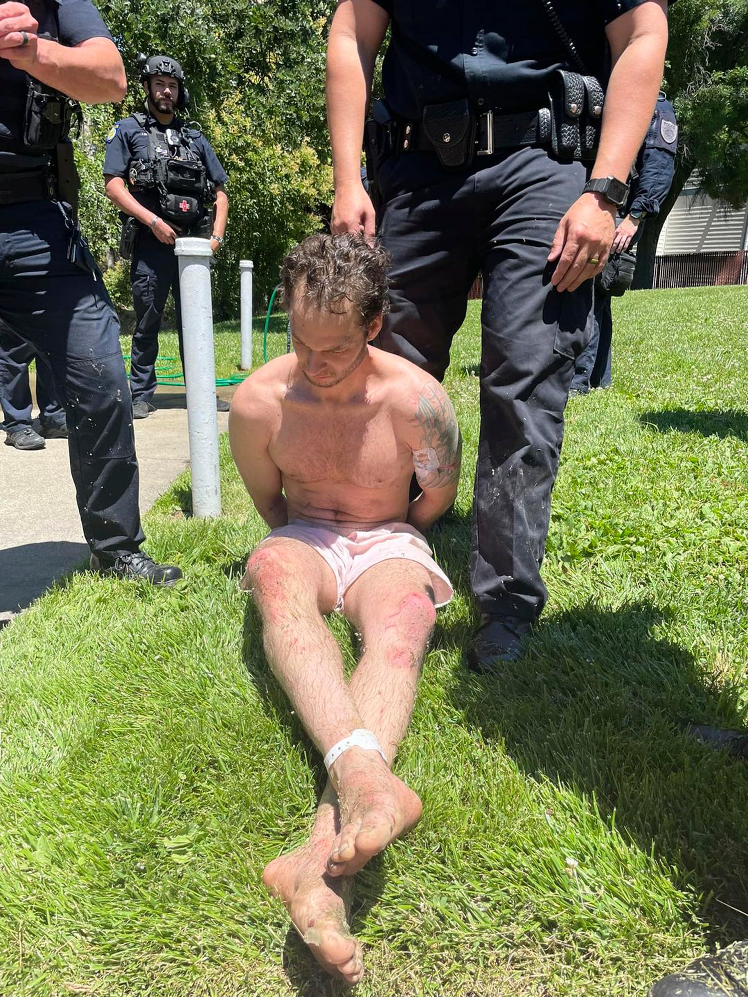Fugitive Eric Abril sits after being taken into custody by police in Rocklin