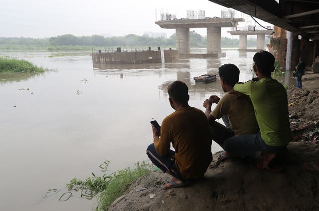 <p>People watch the bank of Yamuna river as the water level increases at the old bridge in Delhi</p>