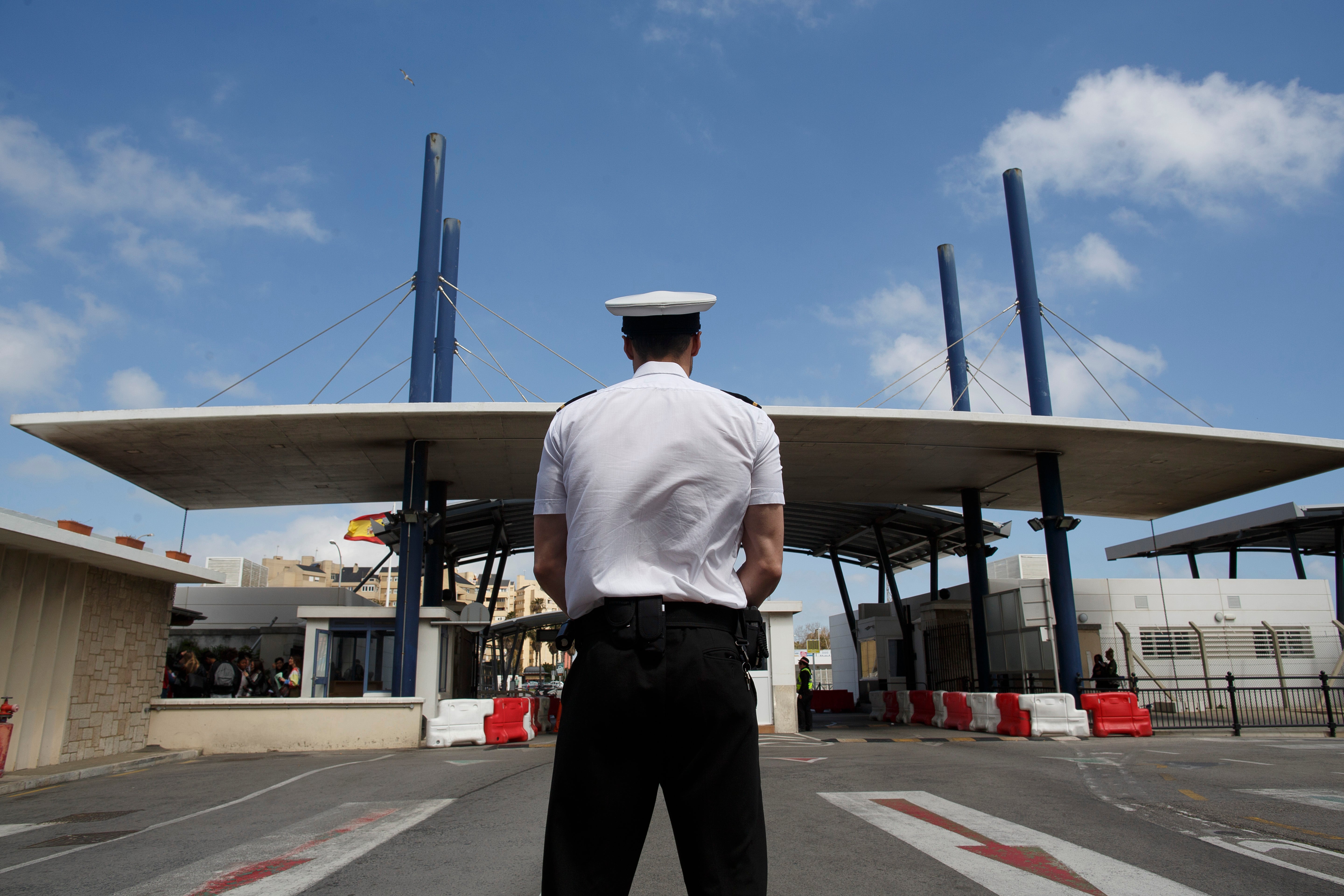 A HM Customs officer stands at the border from Spain to Gibraltar