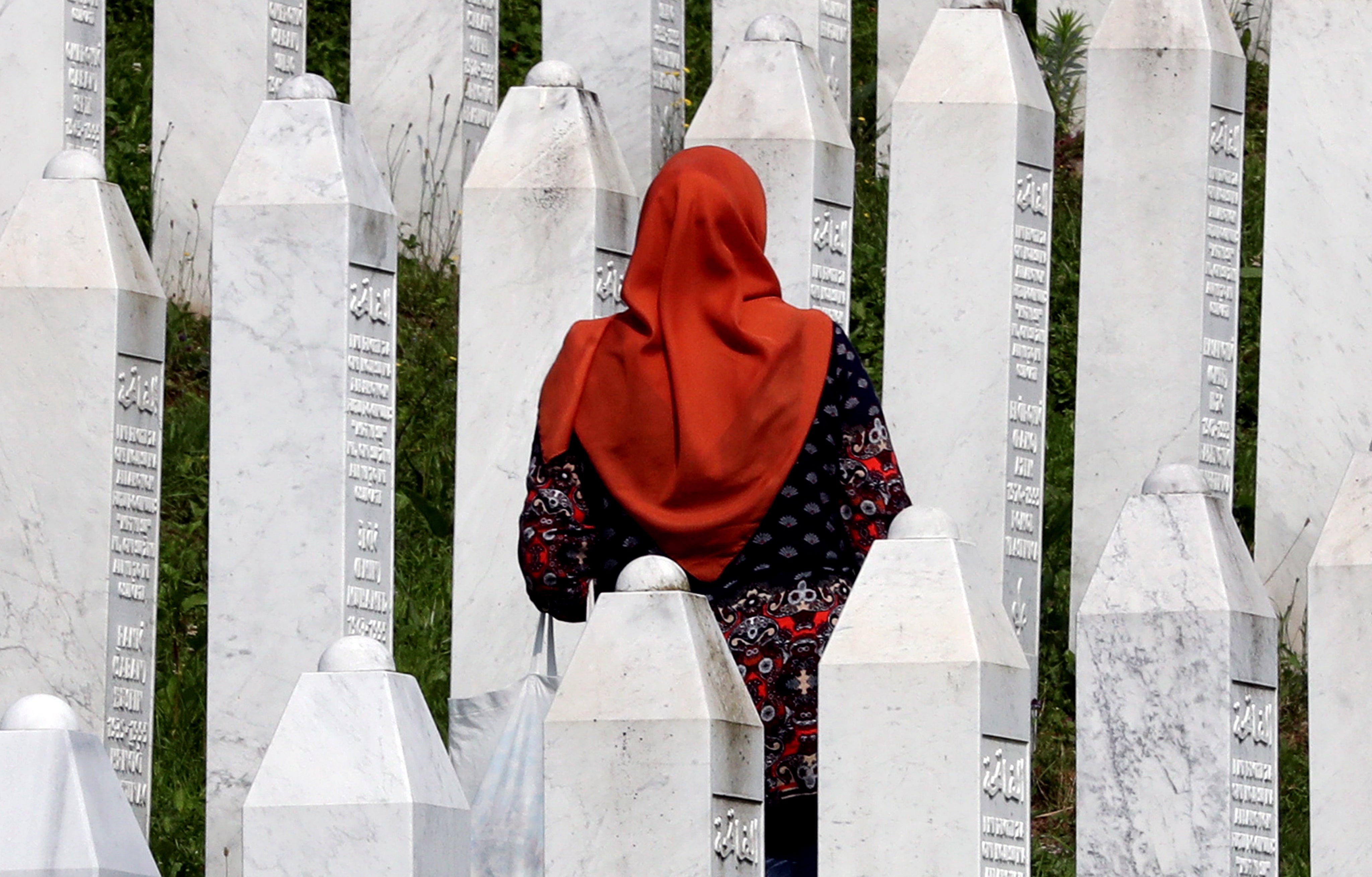 A woman visits gravestones during a funeral ceremony for thirty newly-identified Bosnian Muslim victims, at the Potocari Memorial Center and Cemetery, in Srebrenica, Bosnia and Herzegovina. The burial was part of a memorial ceremony to mark the 28th anniversary of the Srebrenica genocide