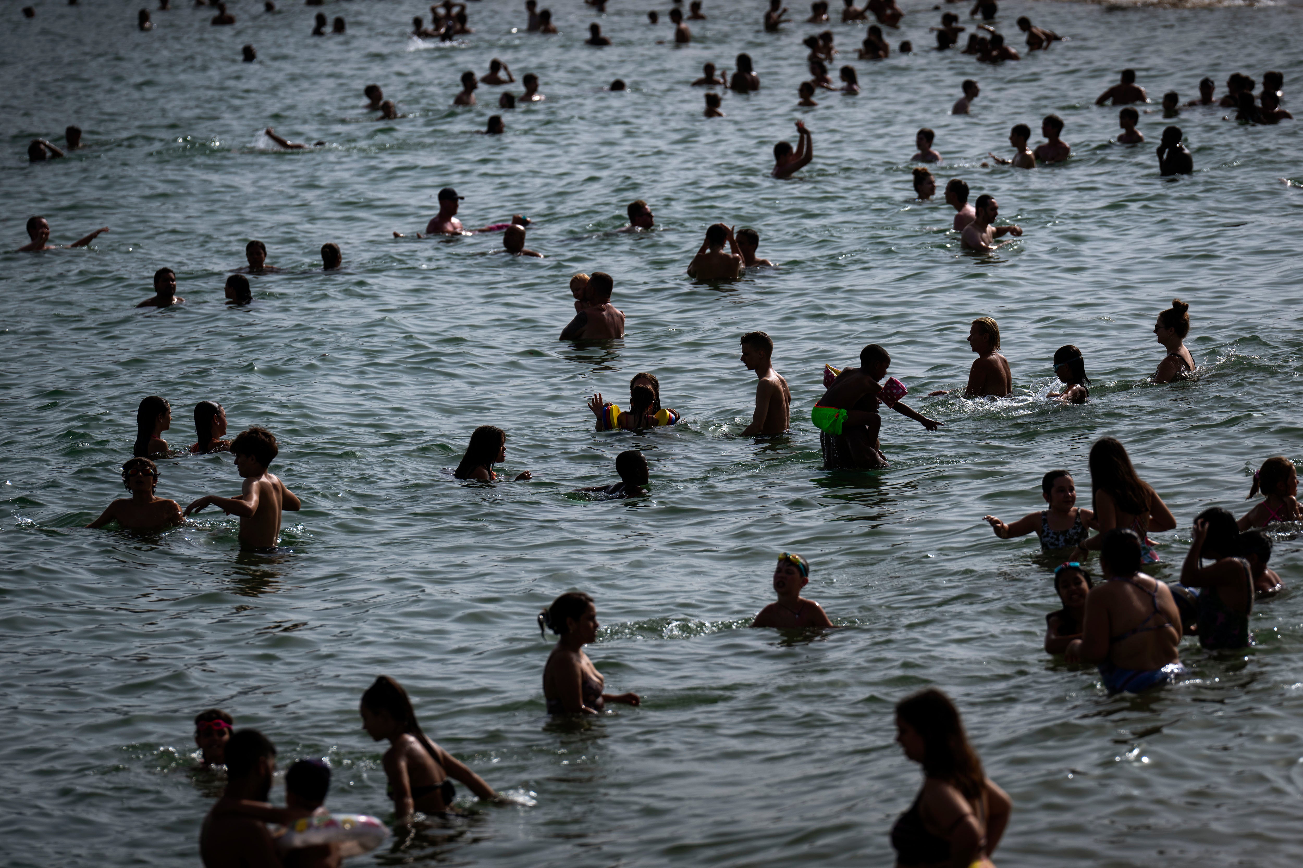 People cool off on a beach in Barcelona