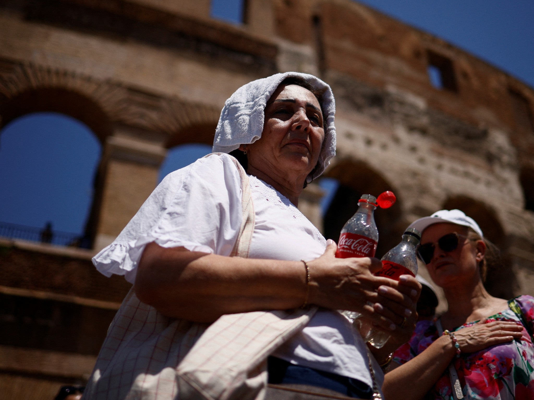 A woman tries to shelter from the heat near the Colosseum in Rome