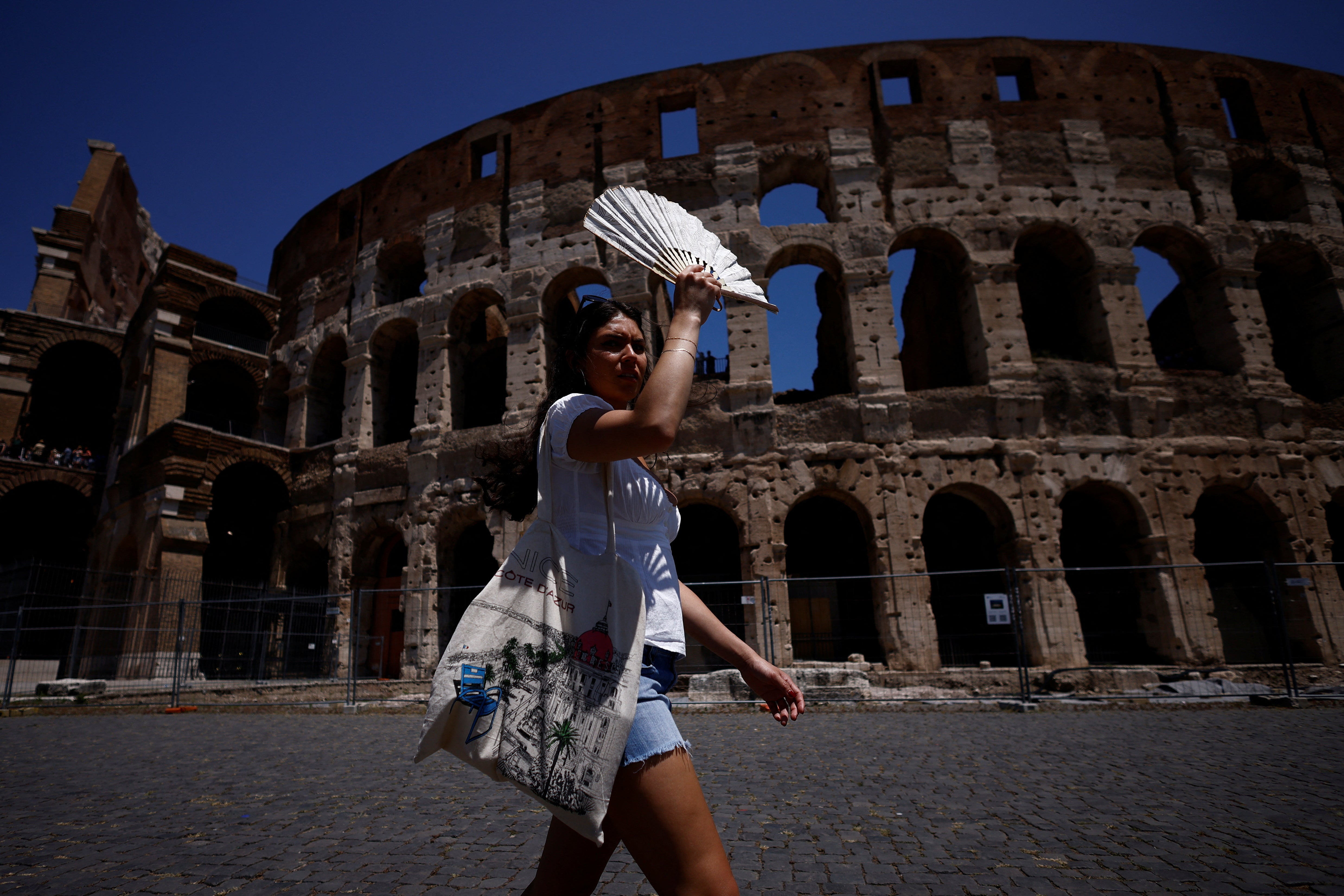 Visitors have been pictured using fans and clothing to shelter from the sun
