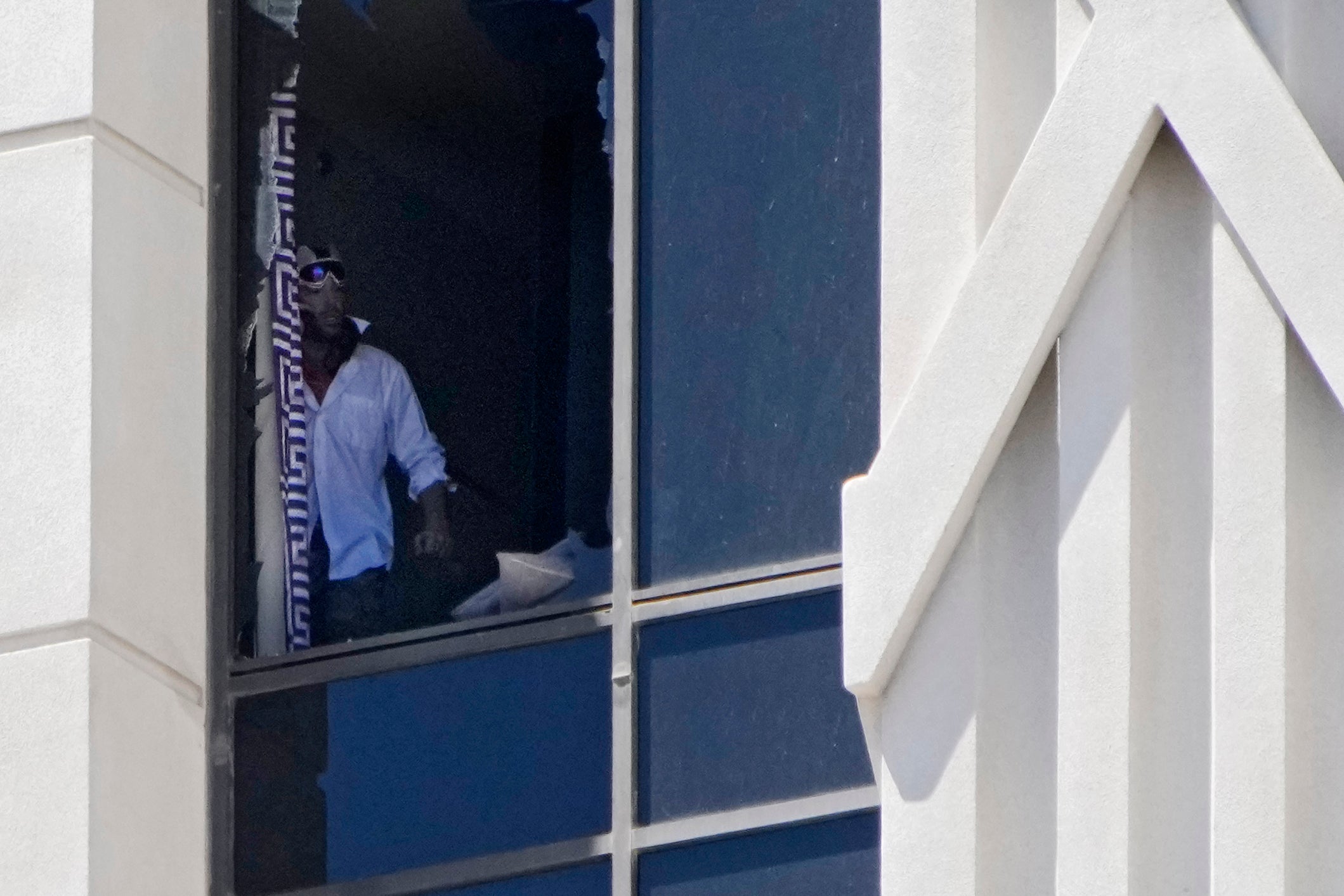 A person looks out a broken window on a hotel tower at Caesars Palace hotel-casino, Tuesday, July 11, 2023, in Las Vegas