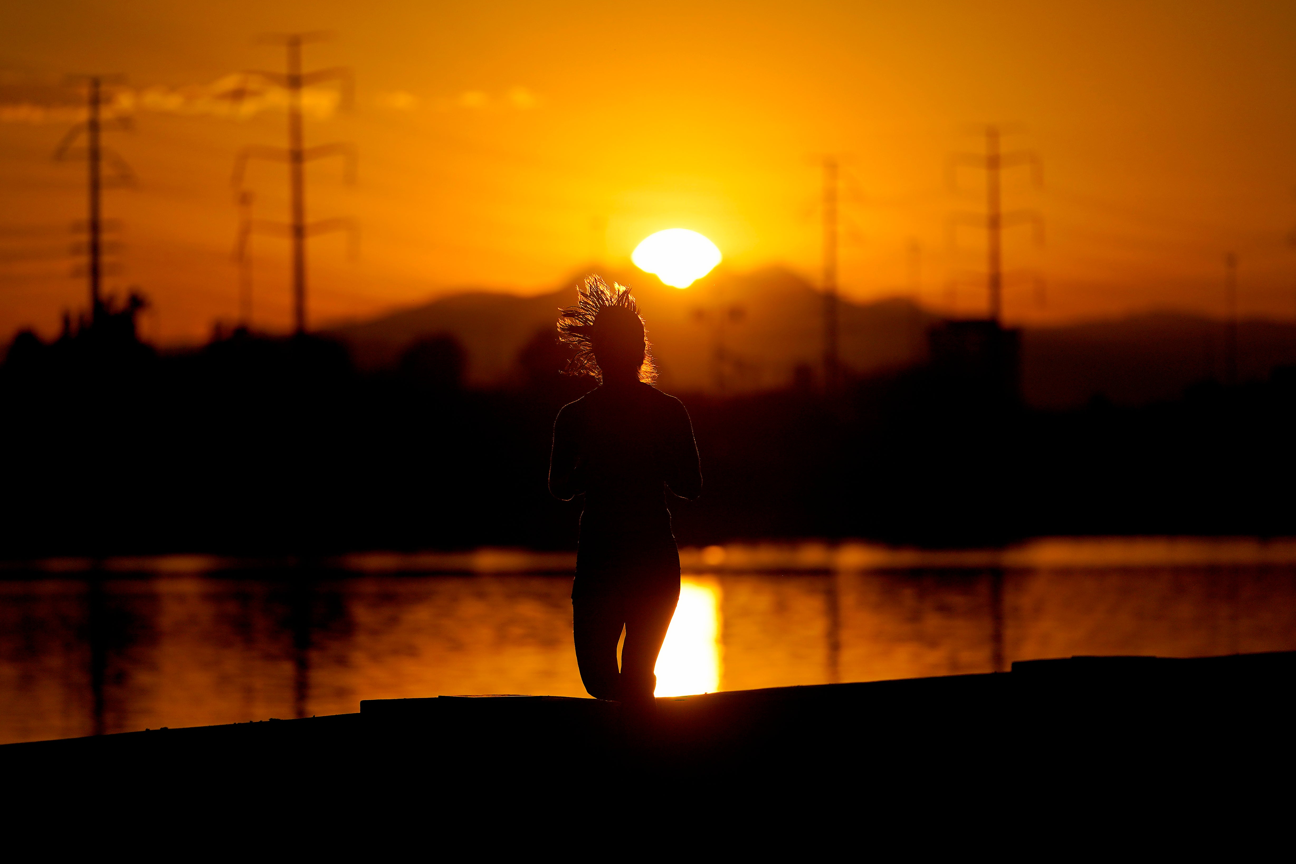 A runner jogs in Tempe, Arizona at sunrise