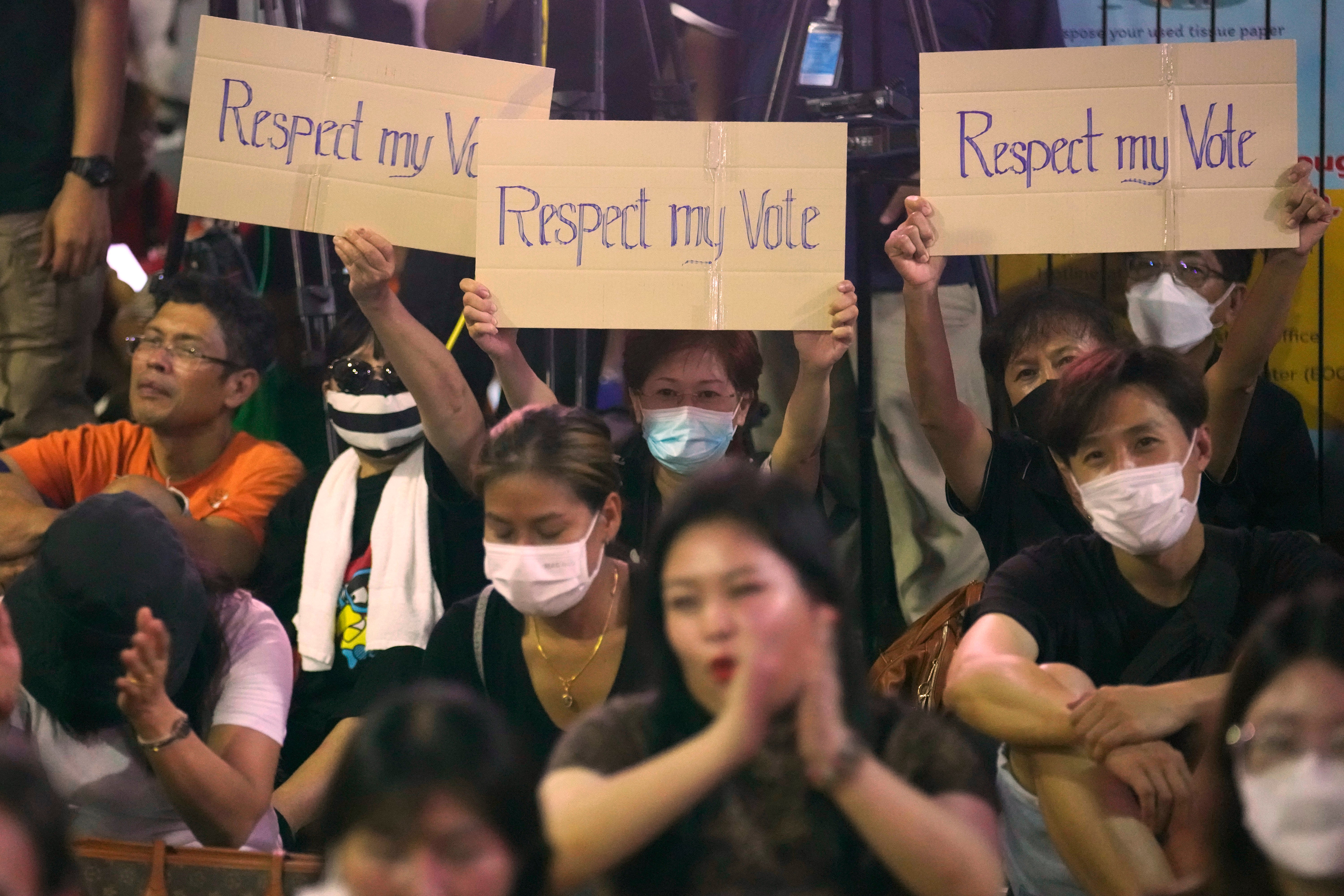 Supporters of Move Forward Party hold posters during a protest in Bangkok