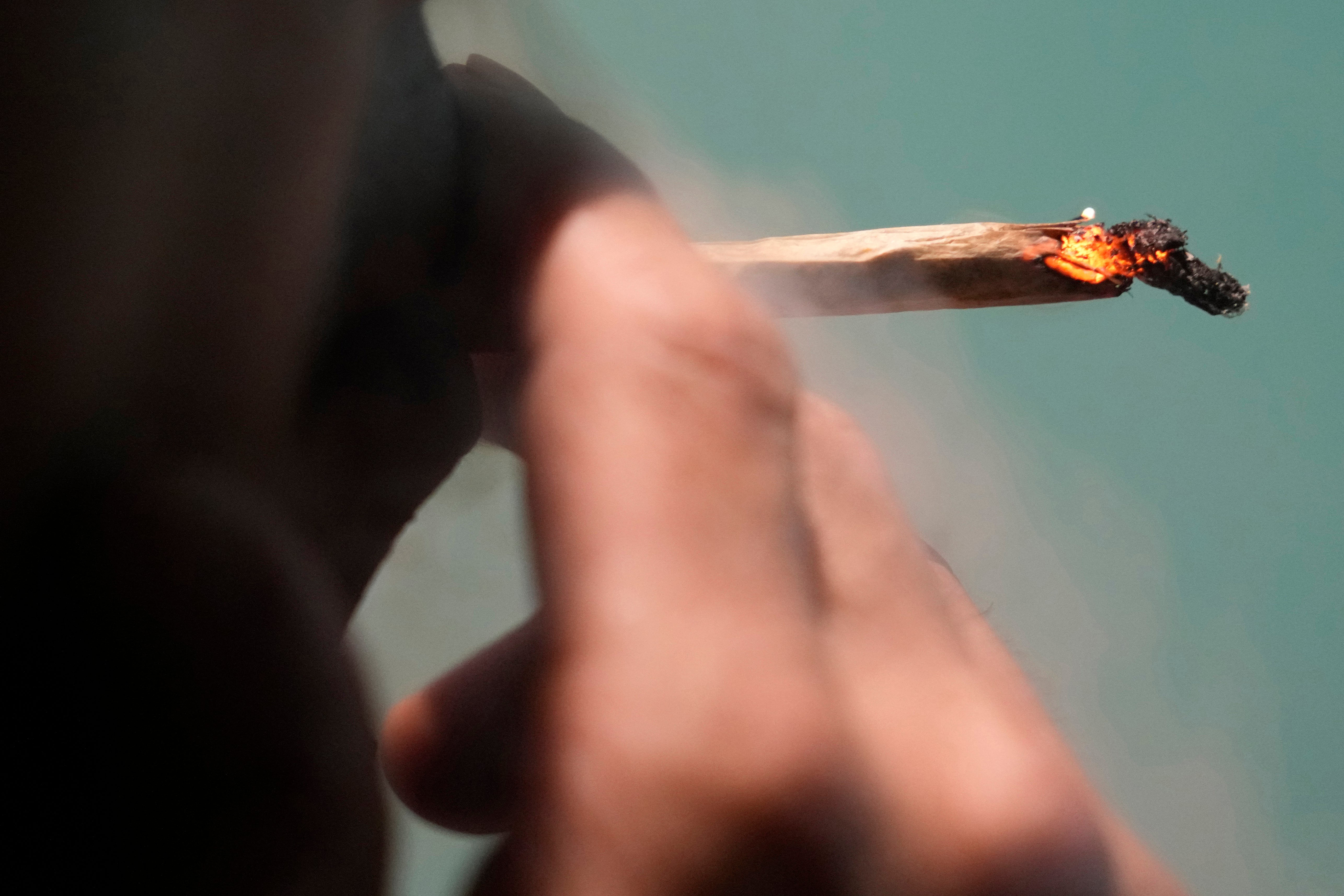 A Japanese tourist smokes cannabis at a Dutch passion shop in Bangkok, Thailand