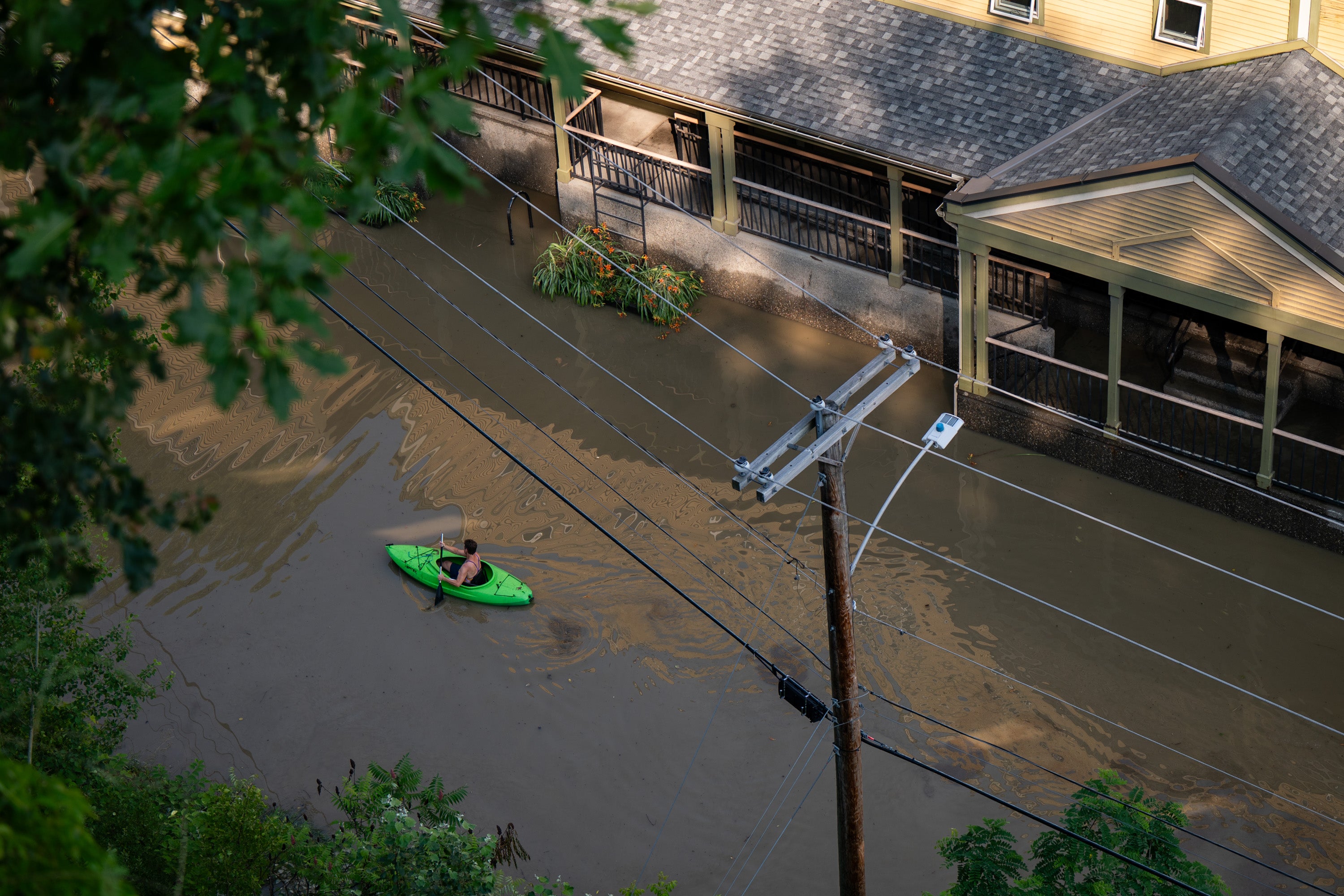 In an aerial view, a kayaker paddles through the flooded waters of Elm Street