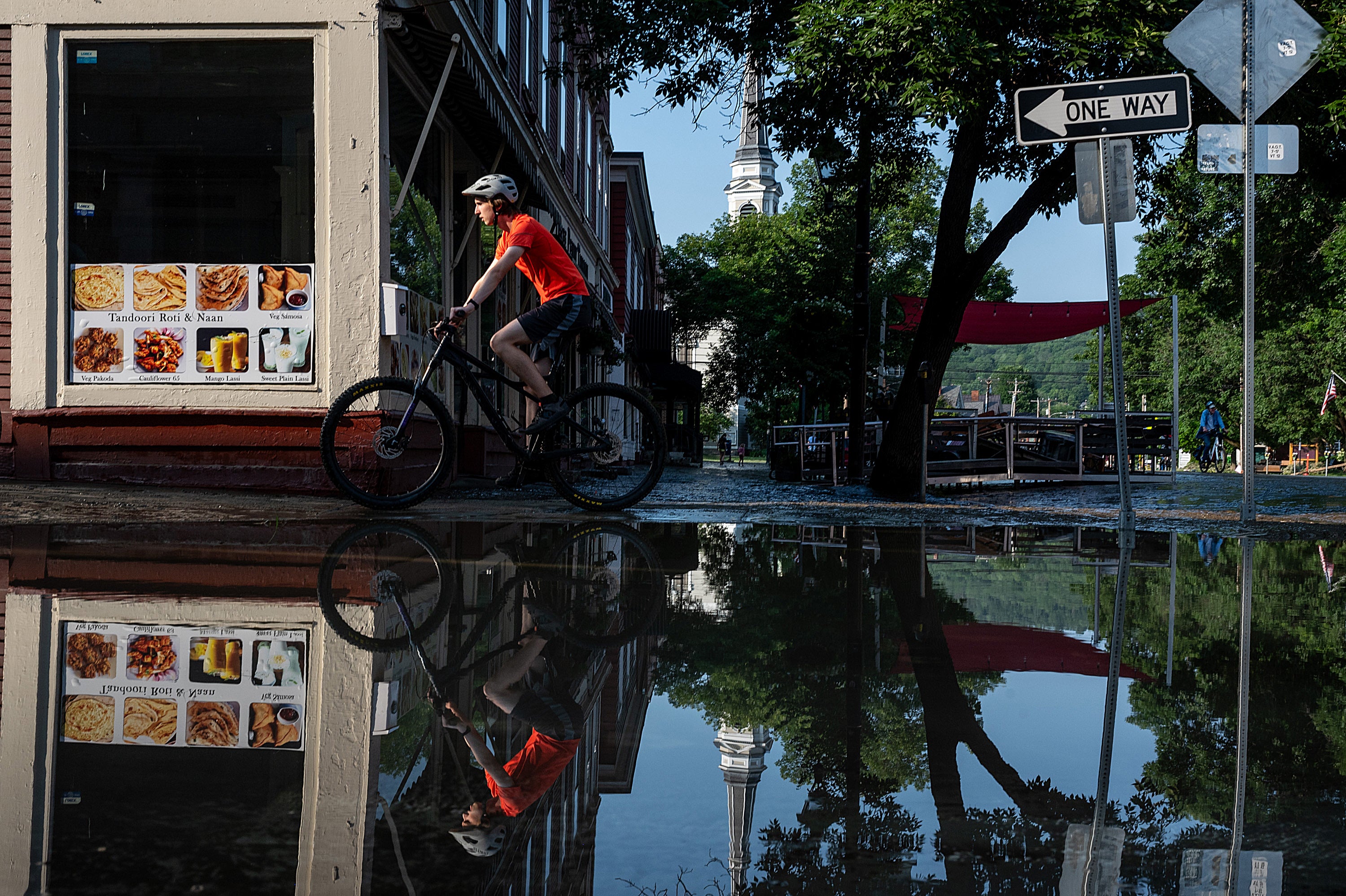 A person bikes around downtown once flood waters receded