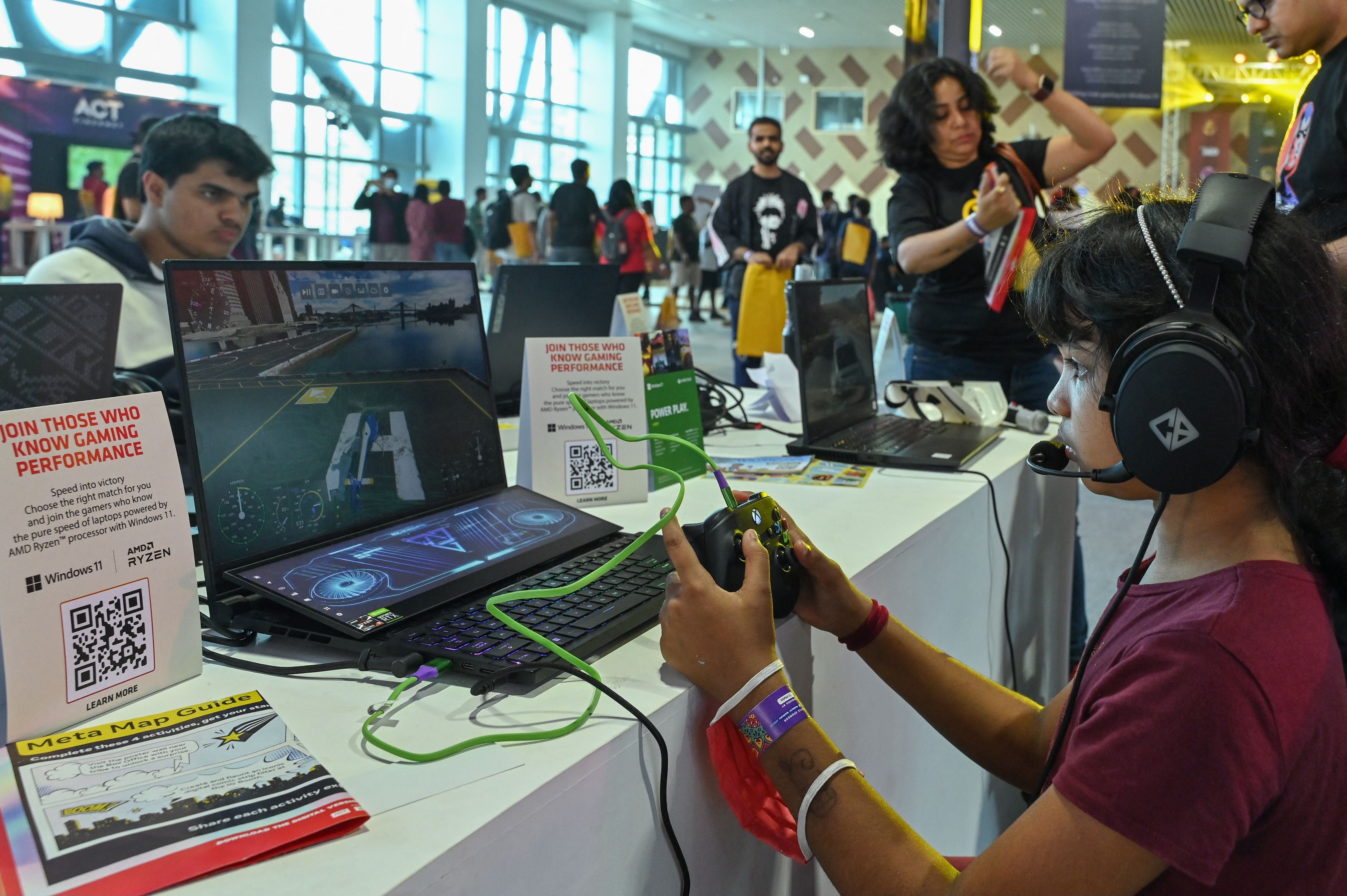 A visitor plays ac computer game during the opening day of the two-day comic book and cosplay characters convention ‘Bengaluru Comic Con 2022’ in Bengaluru on November 19, 2022