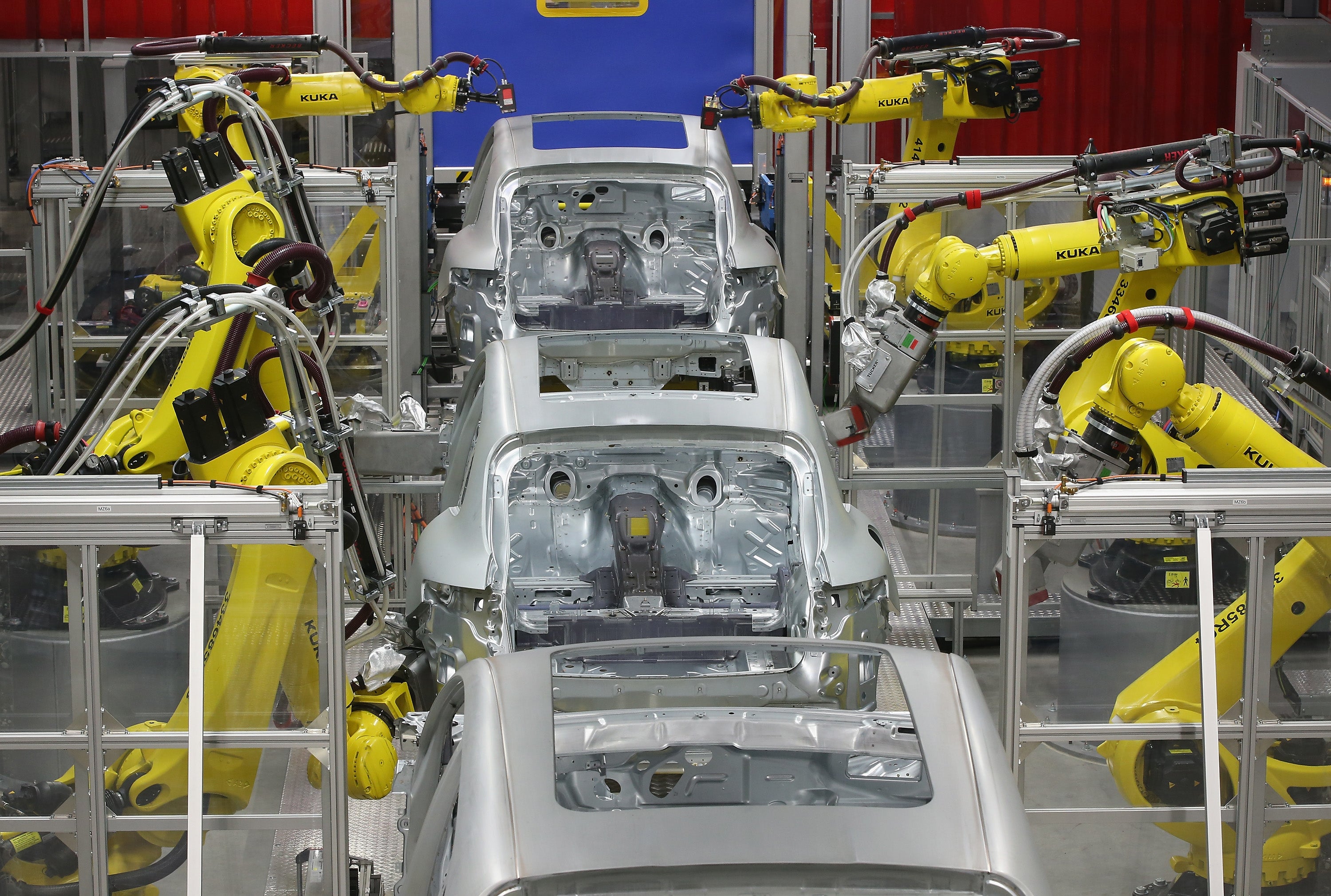 Robots weld the bodies of Porsche Macan SUVs at the Porsche Macan factory in Leipzig.