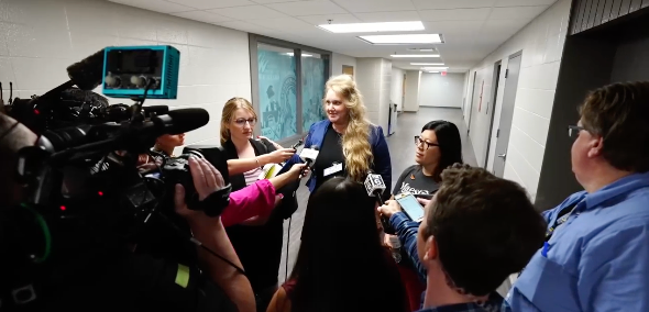 Wisconsin teacher Melissa Tempel and her attorney speak with reporters on 12 July, 2023, after the educator was fired for criticising a district decision not to let children sing a Miley Cyrus song about rainbows.