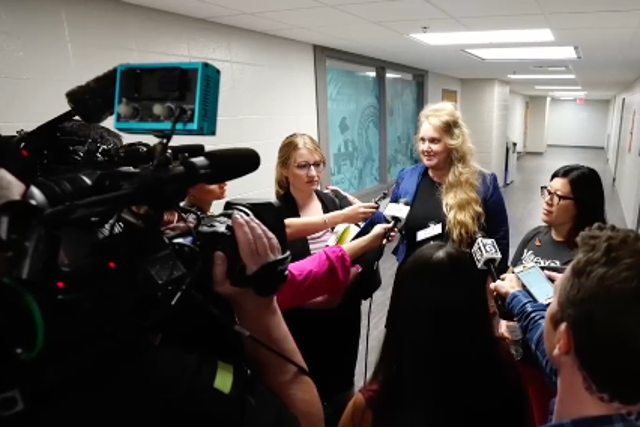 <p>Wisconsin teacher Melissa Tempel and her attorney speak with reporters on 12 July, 2023, after the educator was fired for criticising a district decision not to let children sing a Miley Cyrus song about rainbows.</p>