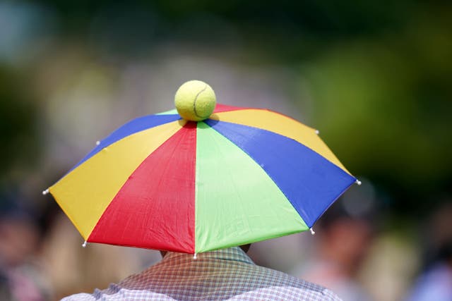 A tennis fan sports an umbrella hat on day nine of the 2023 Wimbledon Championships (Adam Davy/PA)