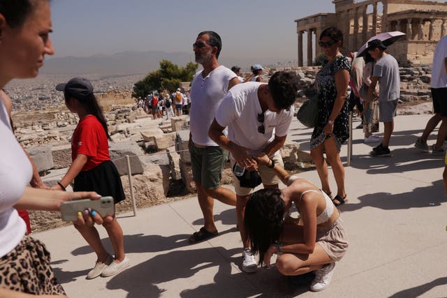 <p>A visitor is affected by the heat atop the Acropolis hill, during a heatwave in Athens, Greece, July 14, 2023</p>