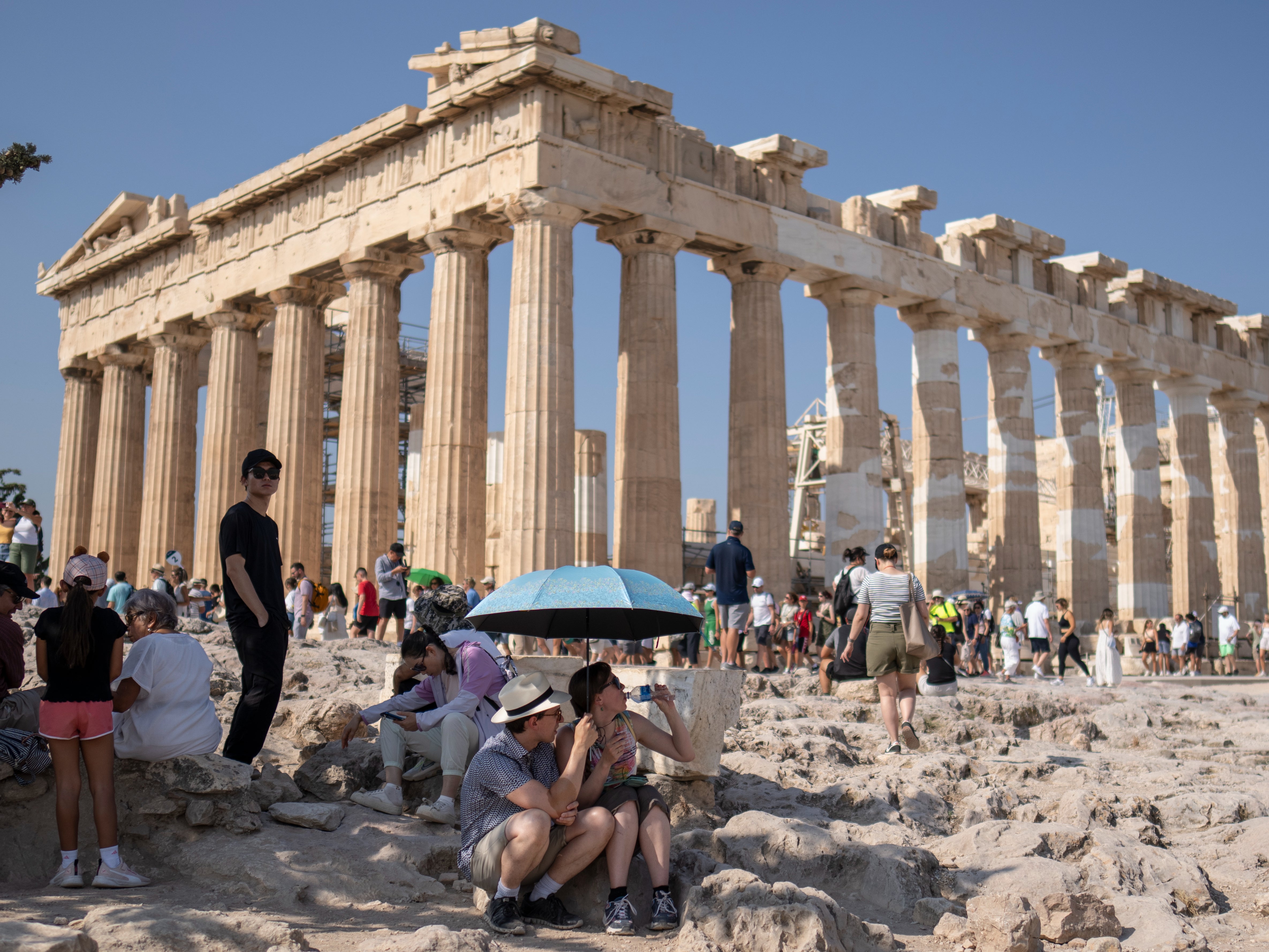 Tourists used umbrellas for shade at the Parthenon