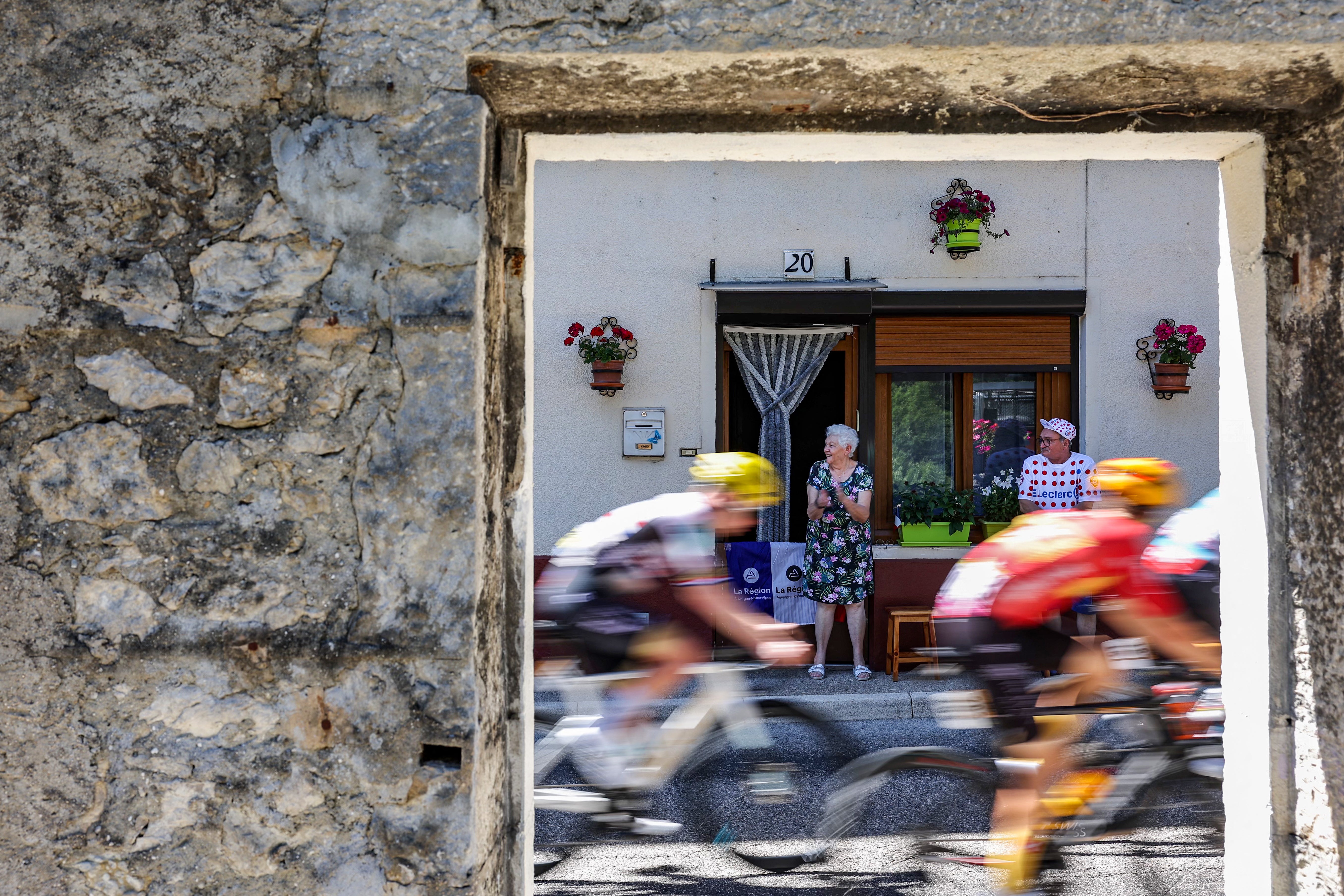 Riders cycle past spectators along the race route during the 13th stage of the Tour de France, in the Jura mountains.