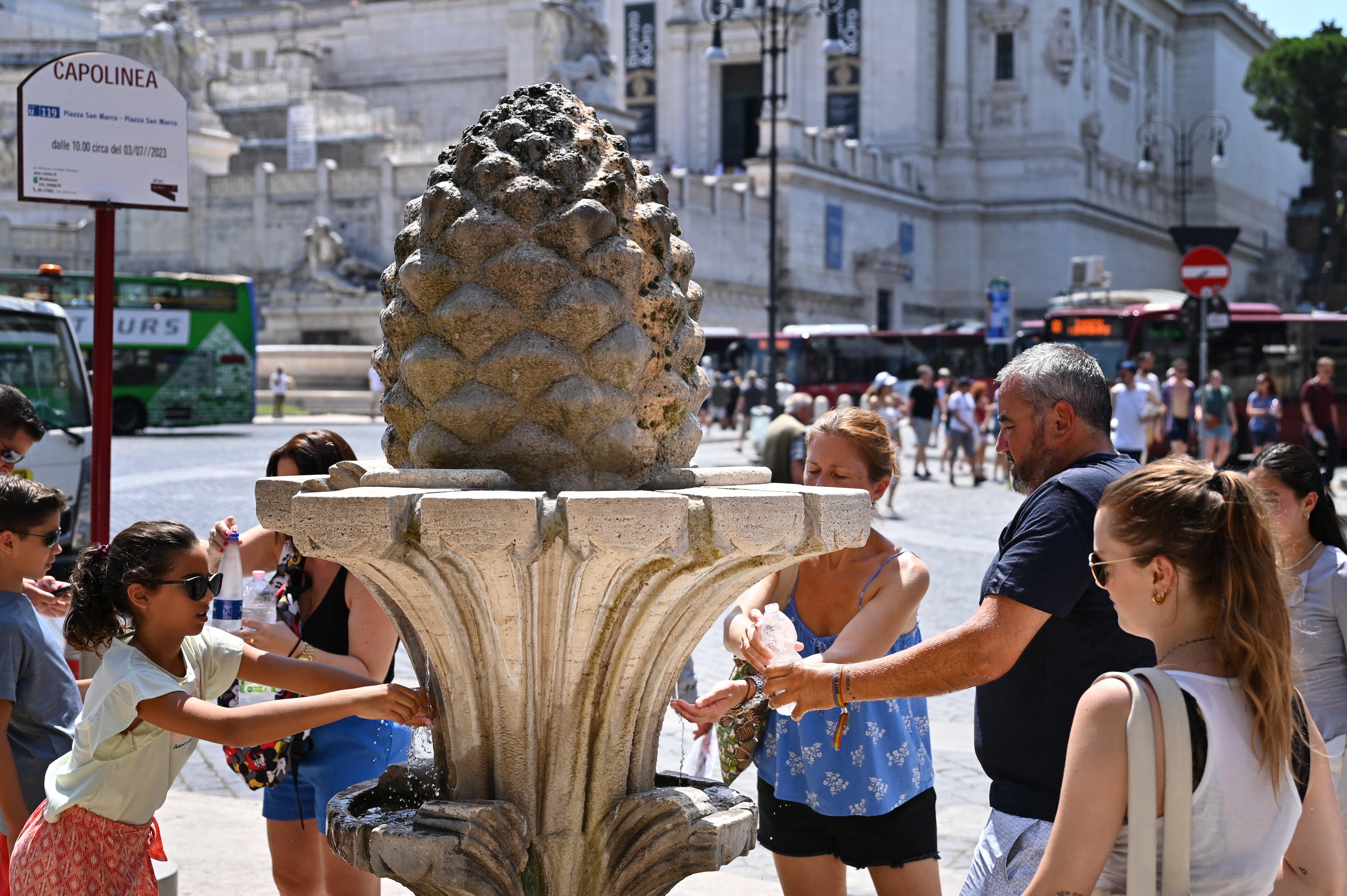 <p>Visitors fill their bottles with water at a fountain in Rome, Italy</p>