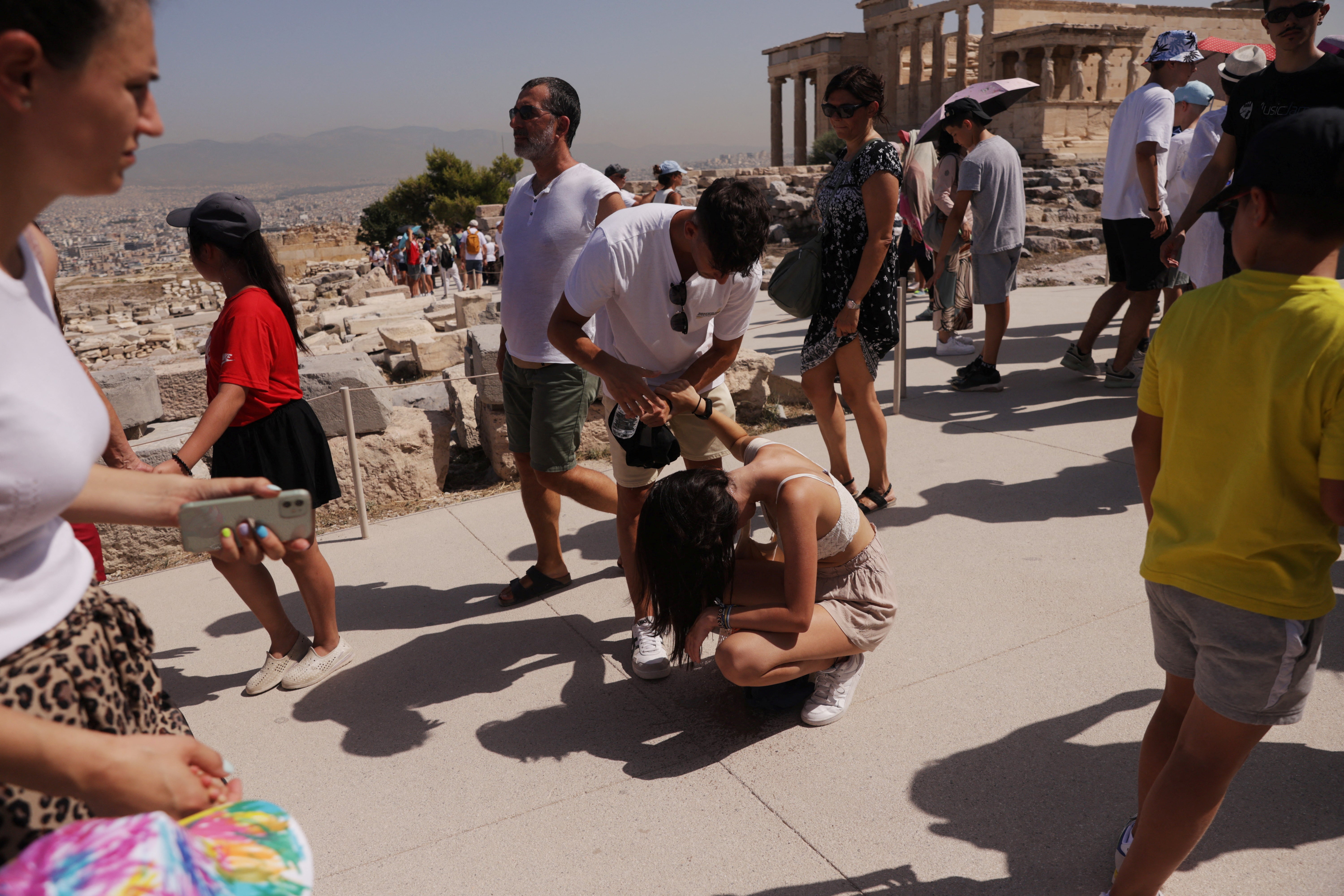 <p>One woman affected by the heatwave atop the Acropolis</p>