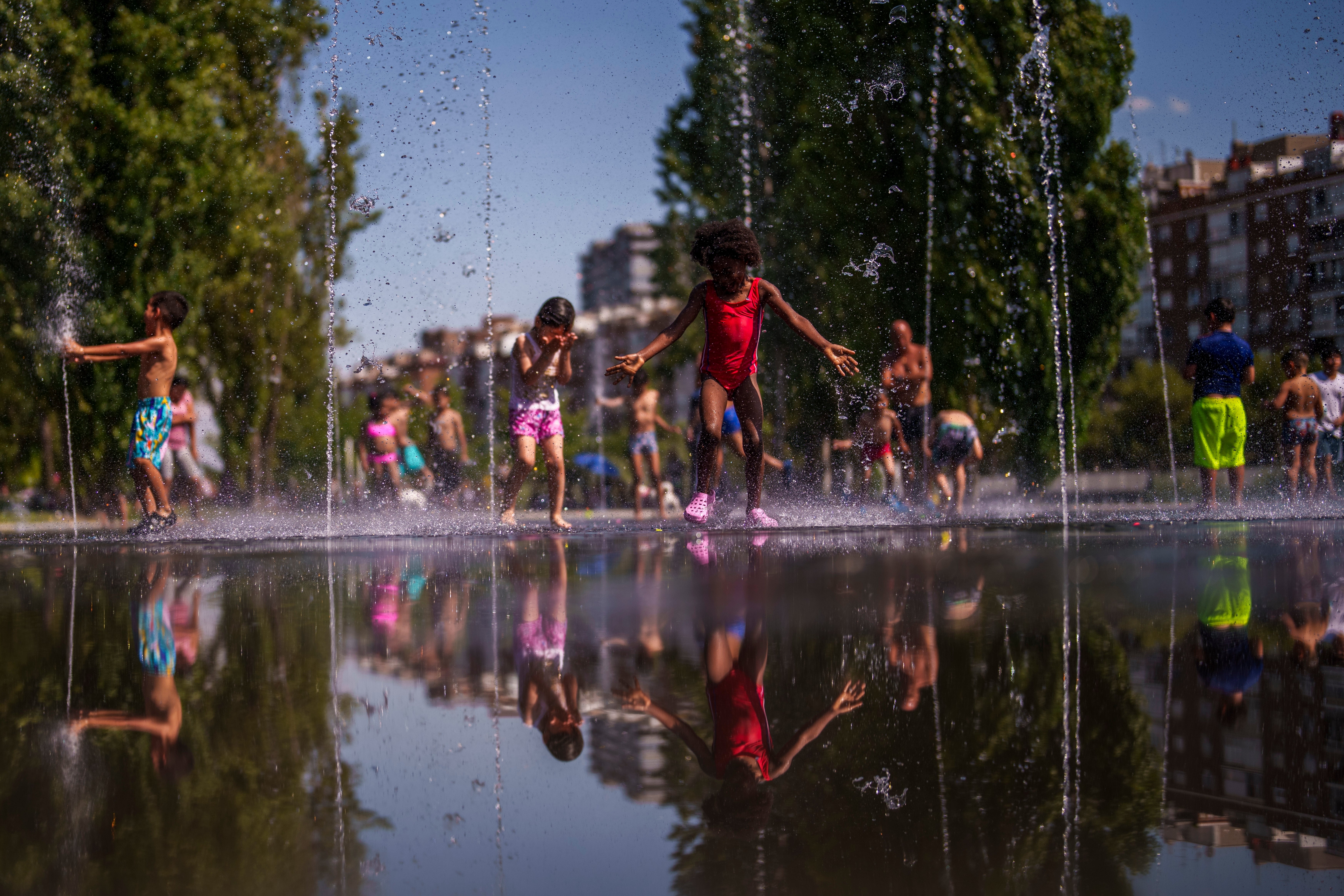 <p>Children cooling off at Madrid Rio park in Madrid, Spain</p>