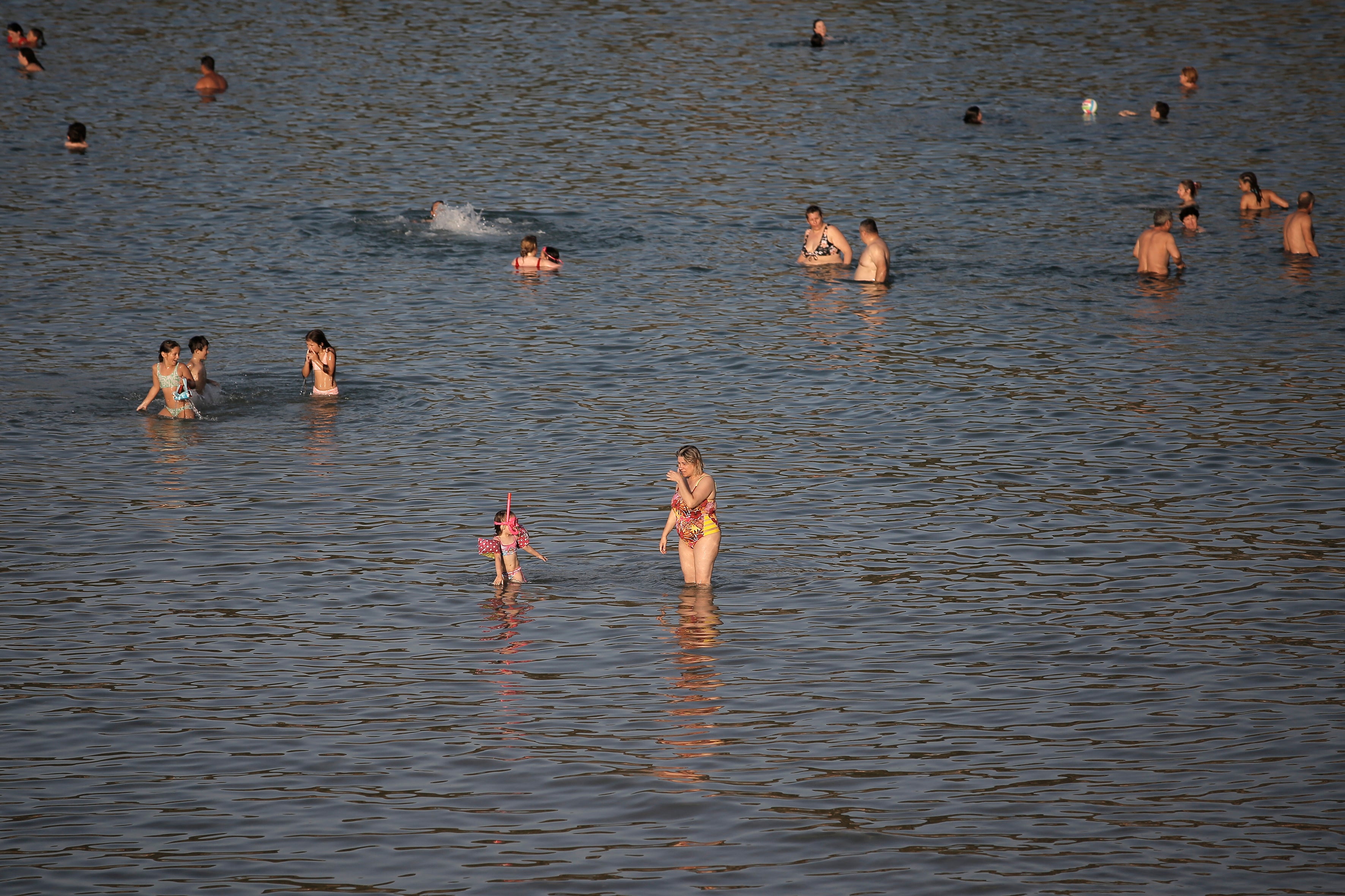 <p>People in Greece take to the beach to cool down on the coast of Varkiza near Athens</p>