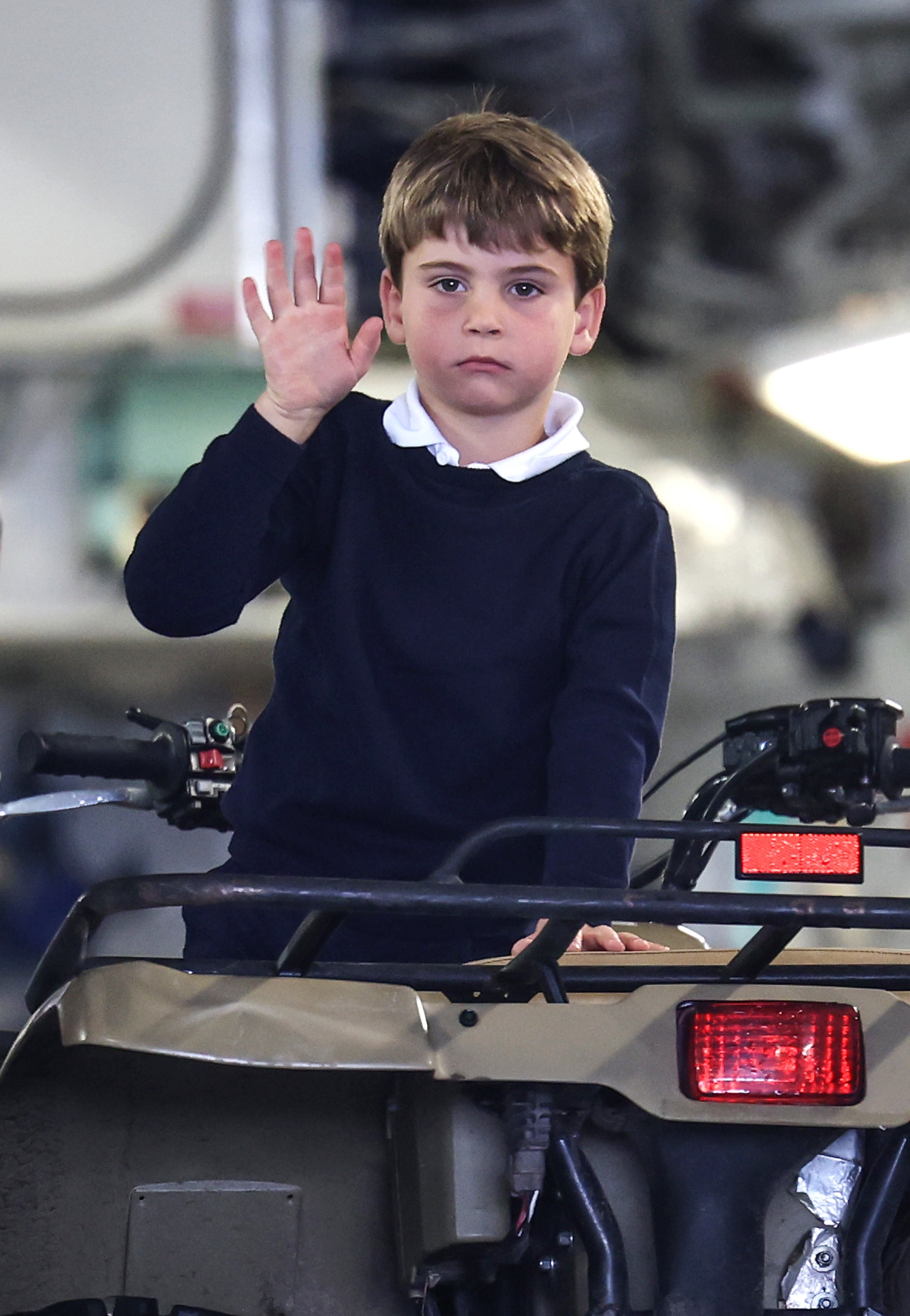 Prince Louis waves whilst sitting on a quad bike during a visit to the Royal International Air Tattoo