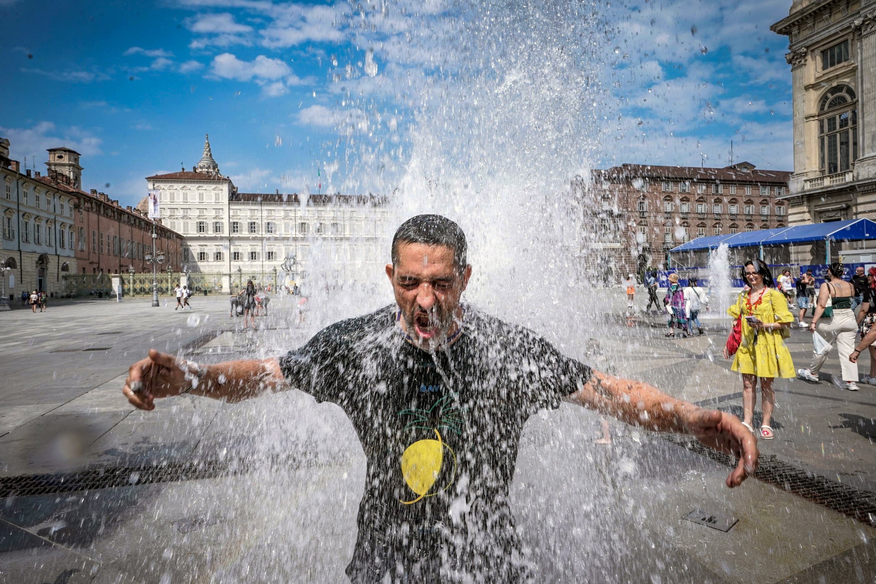 A man cools off in a fountain in Turin, Italy, during the Cerberus heatwave on Saturday