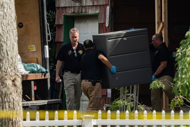 <p>New York State police officers move a metal cabinet as law enforcement searches the home of Rex Heuermann, Saturday, July 15, 2023, in Massapequa Park, N.Y. </p>