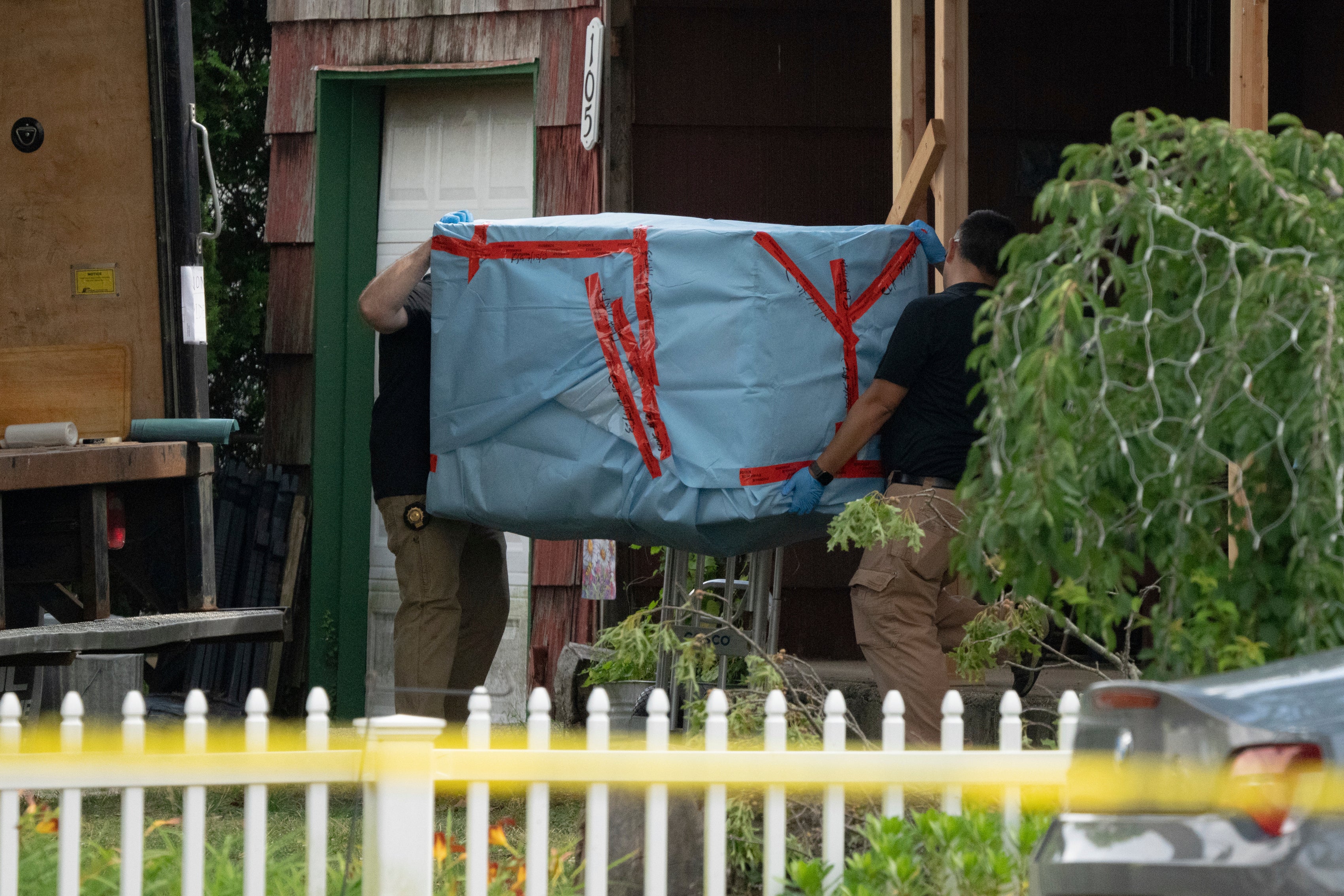 New York State police officers carry out a large item as law enforcement searches the home of Rex Heuermann, Saturday, July 15, 2023, in Massapequa Park, N.Y.
