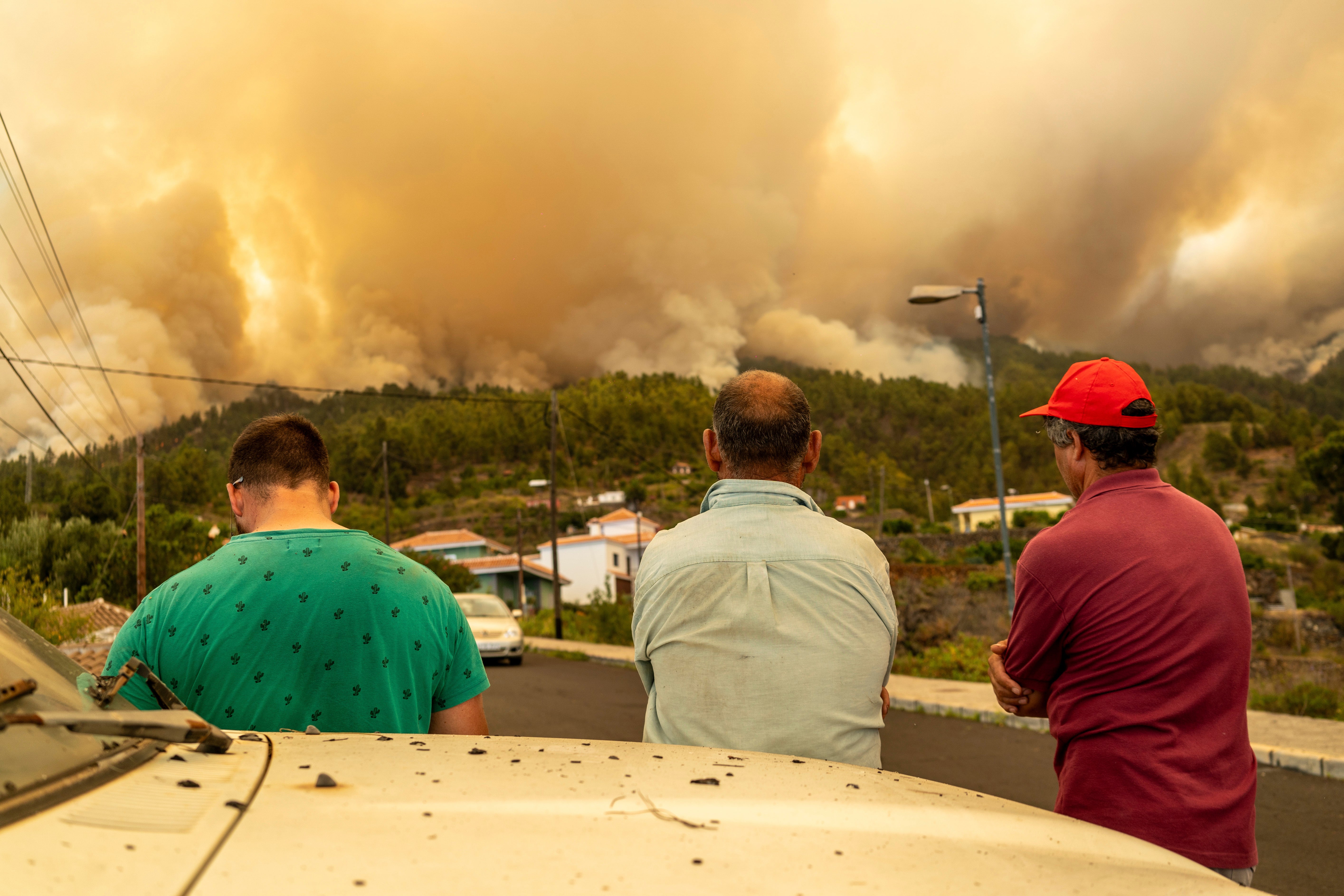 <p>Local residents look on at a burning forest fire, near Puntagorda on the Canary Island of La Palma</p>