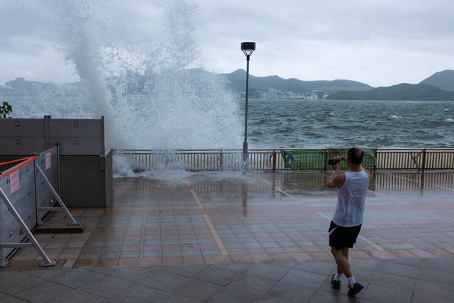 <p>A man looks at the waves on a promenade during a typhoon in Hong Kong</p>