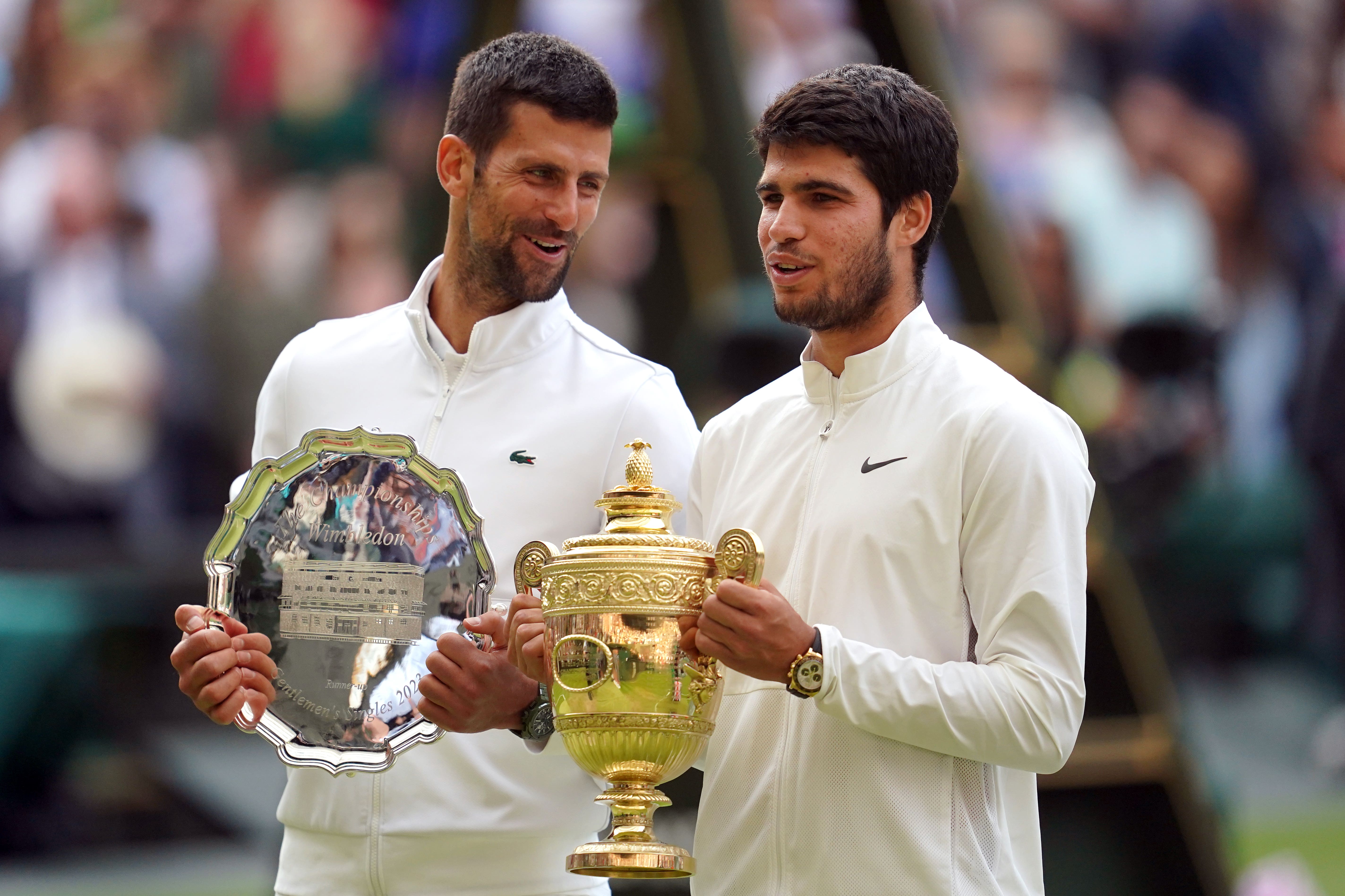 Carlos Alcaraz with the trophy, alongside Novak Djokovic